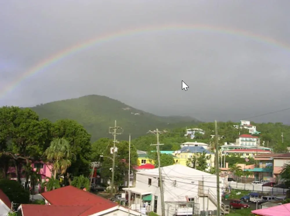 Rainbow over green hills and Cruz Bay Boutique Hotel rooftops near Cruz Bay Boutique Hotel.