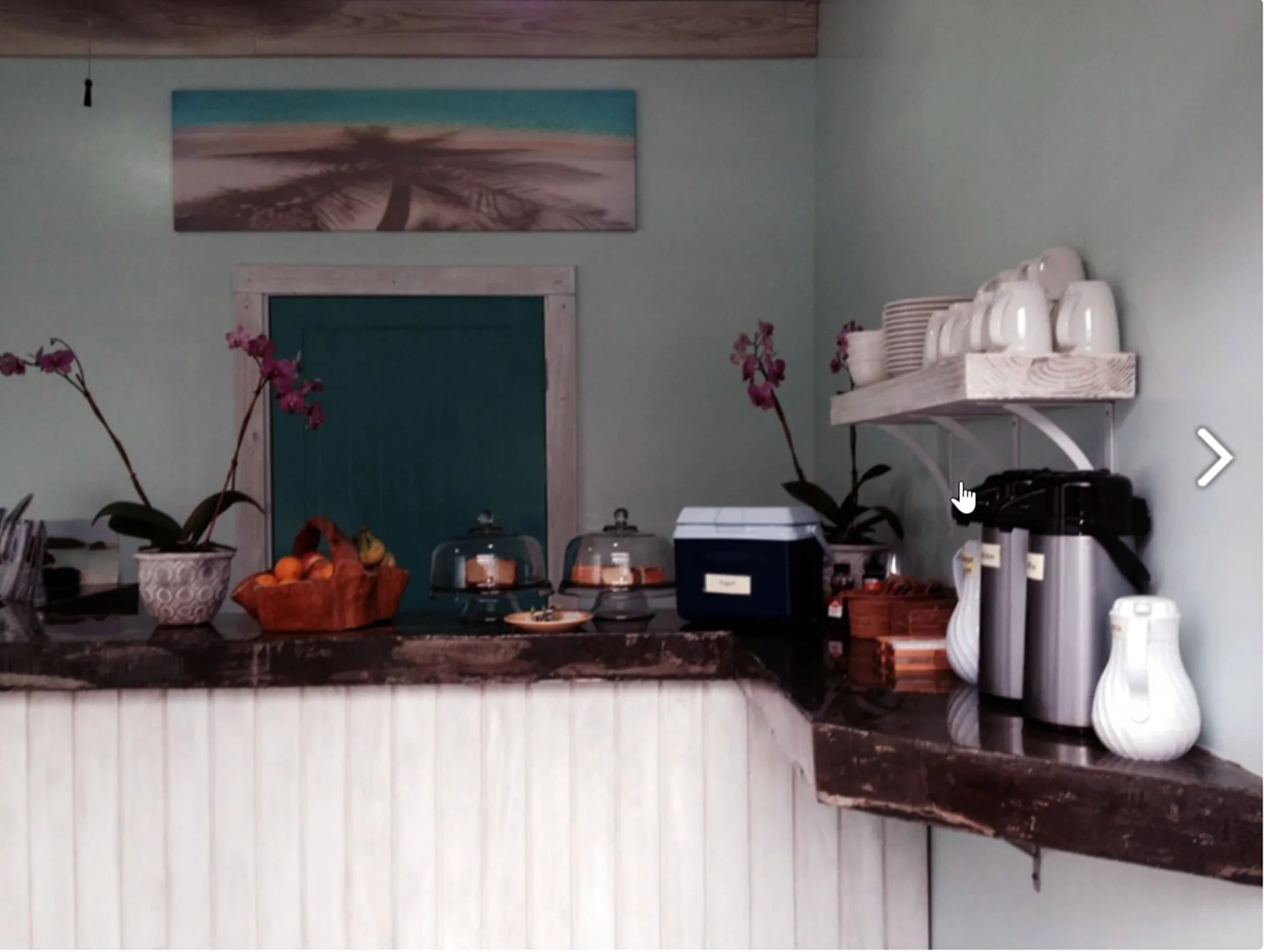 Breakfast counter with coffee, cups, fruit, and pastries at Cruz Bay Boutique Hotel.