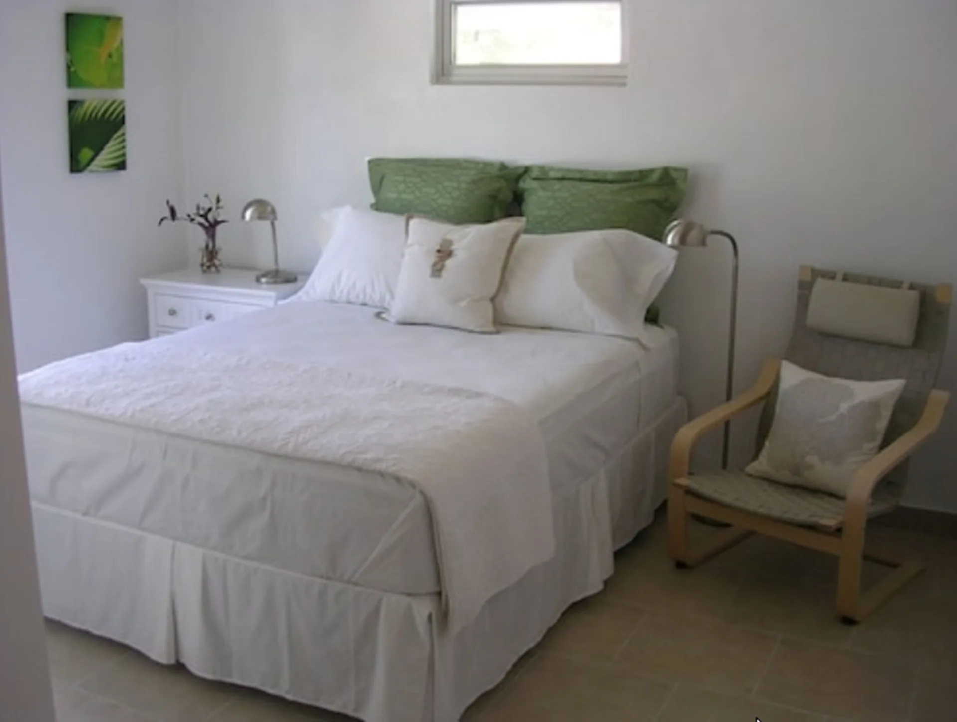 Standard Room bed, nightstand, and armchair at Cruz Bay Boutique Hotel.