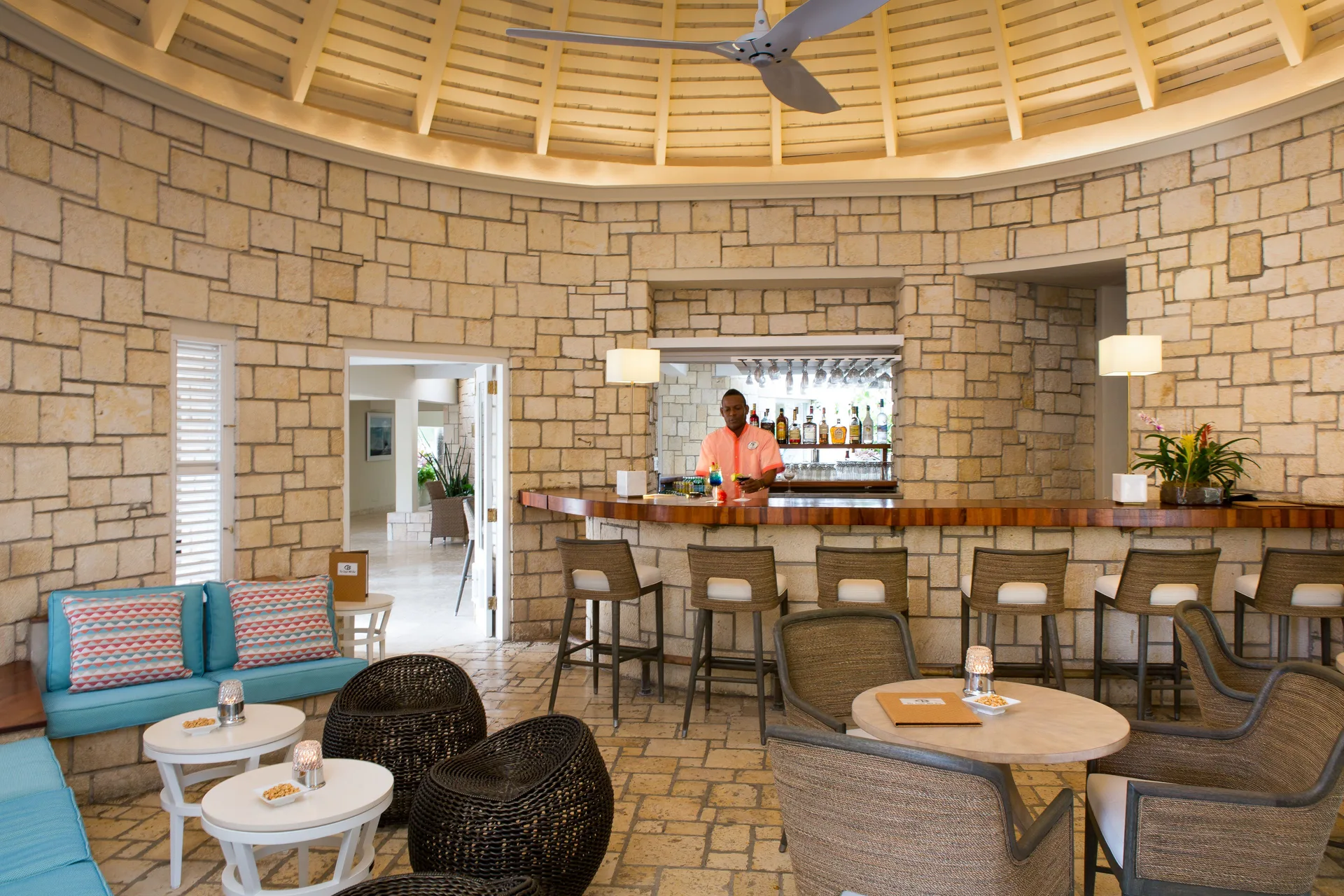 Stone-walled indoor bar with lounge seating at Curtain Bluff Resort.