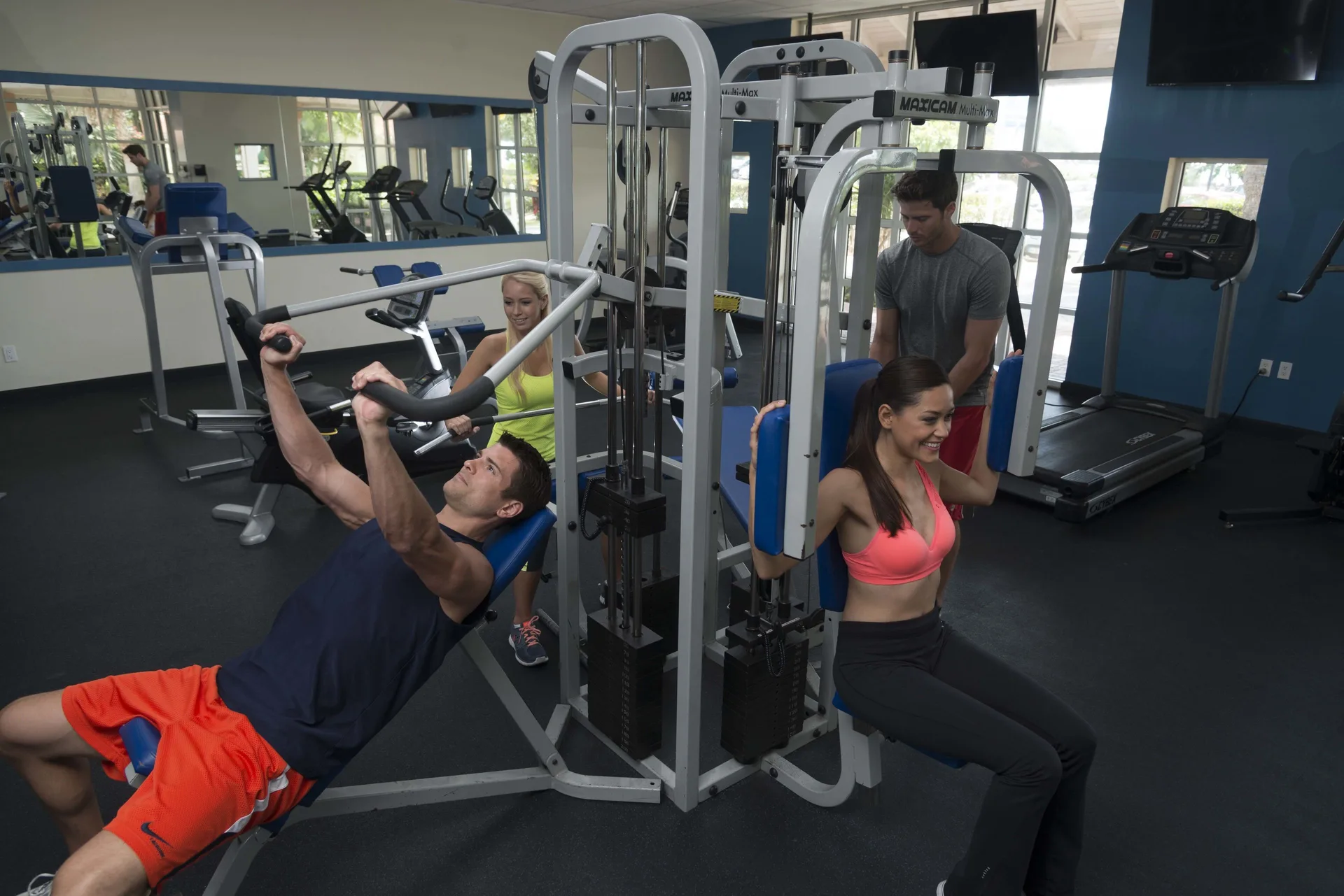 Guests exercise on weight machines in the fitness room at Divi Little Bay Beach Resort.