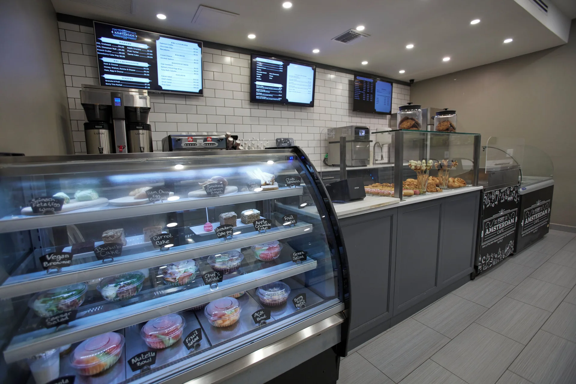 Café counter with display cases and menu screens at Divi Little Bay Beach Resort.