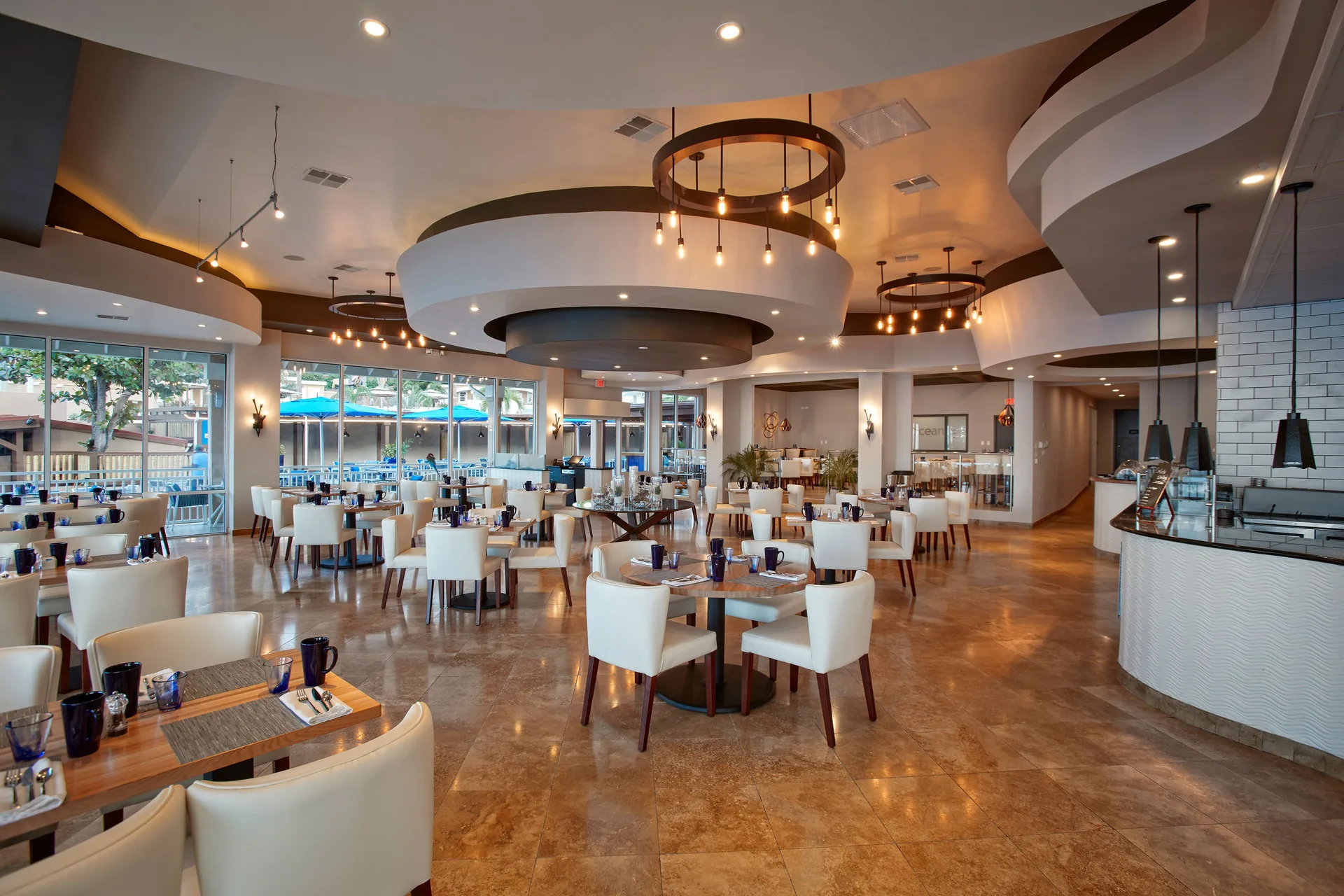 Bright restaurant dining room with set tables at Divi Little Bay Beach Resort.