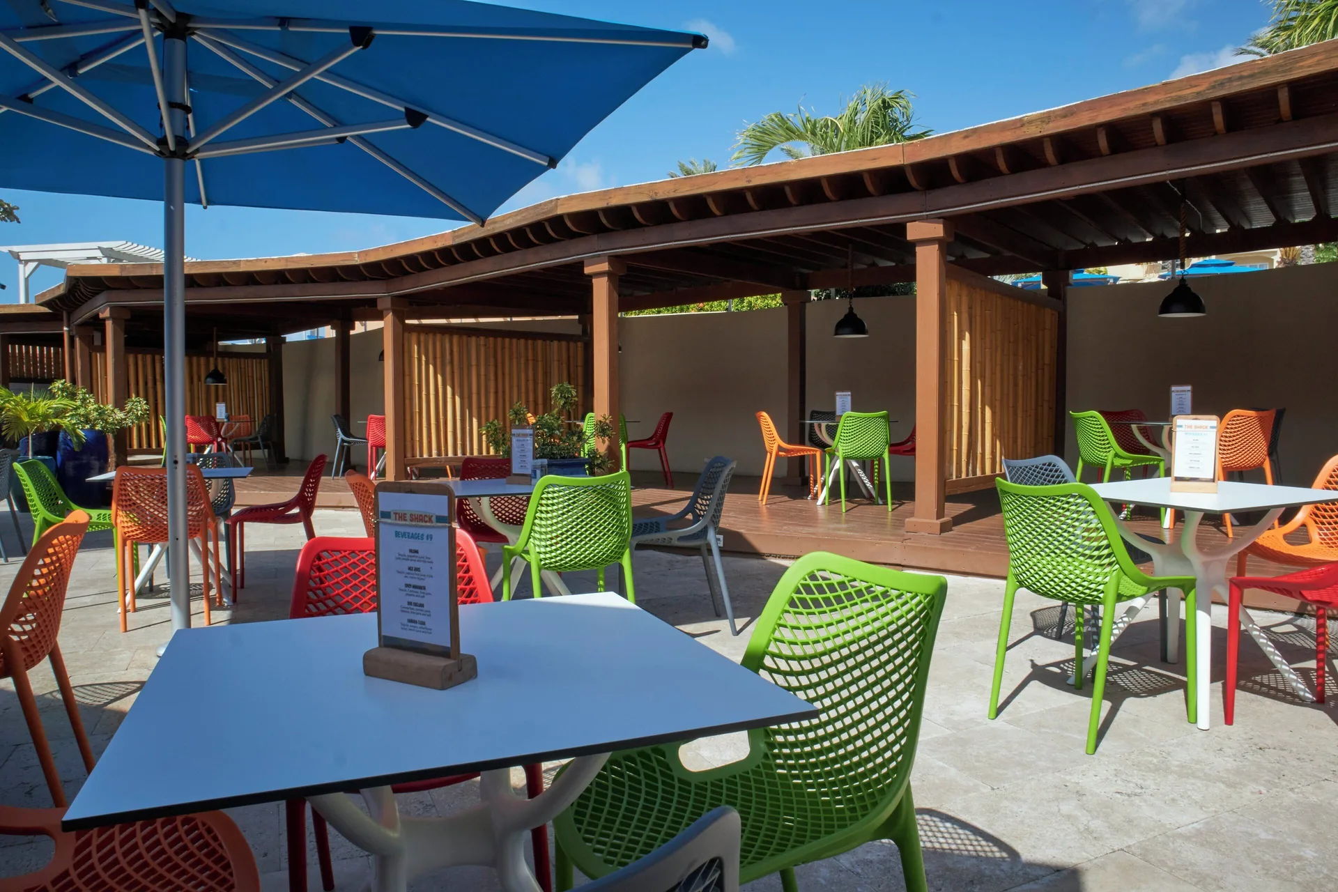 Colorful outdoor tables and chairs at The Shack at Divi Little Bay Beach Resort.