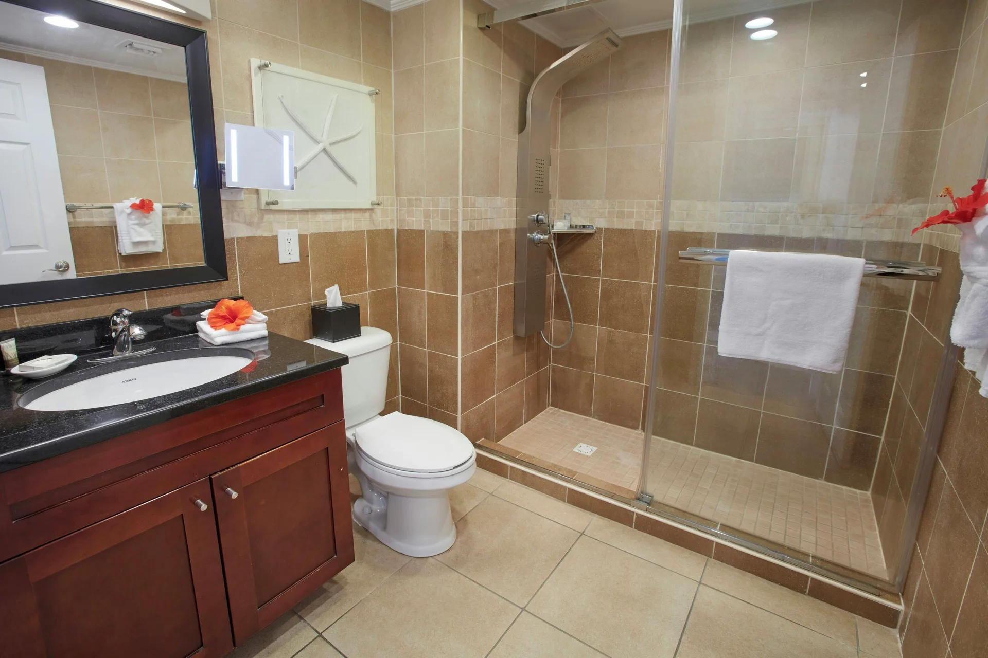 Studio Suite bathroom with glass shower and vanity at Divi Little Bay Beach Resort.