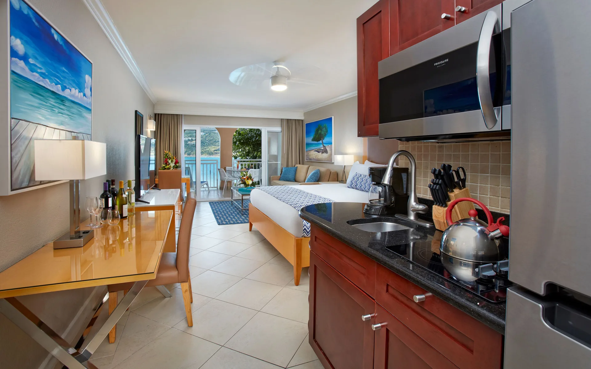 Studio Suite kitchenette and king bed leading to a balcony at Divi Little Bay Beach Resort.