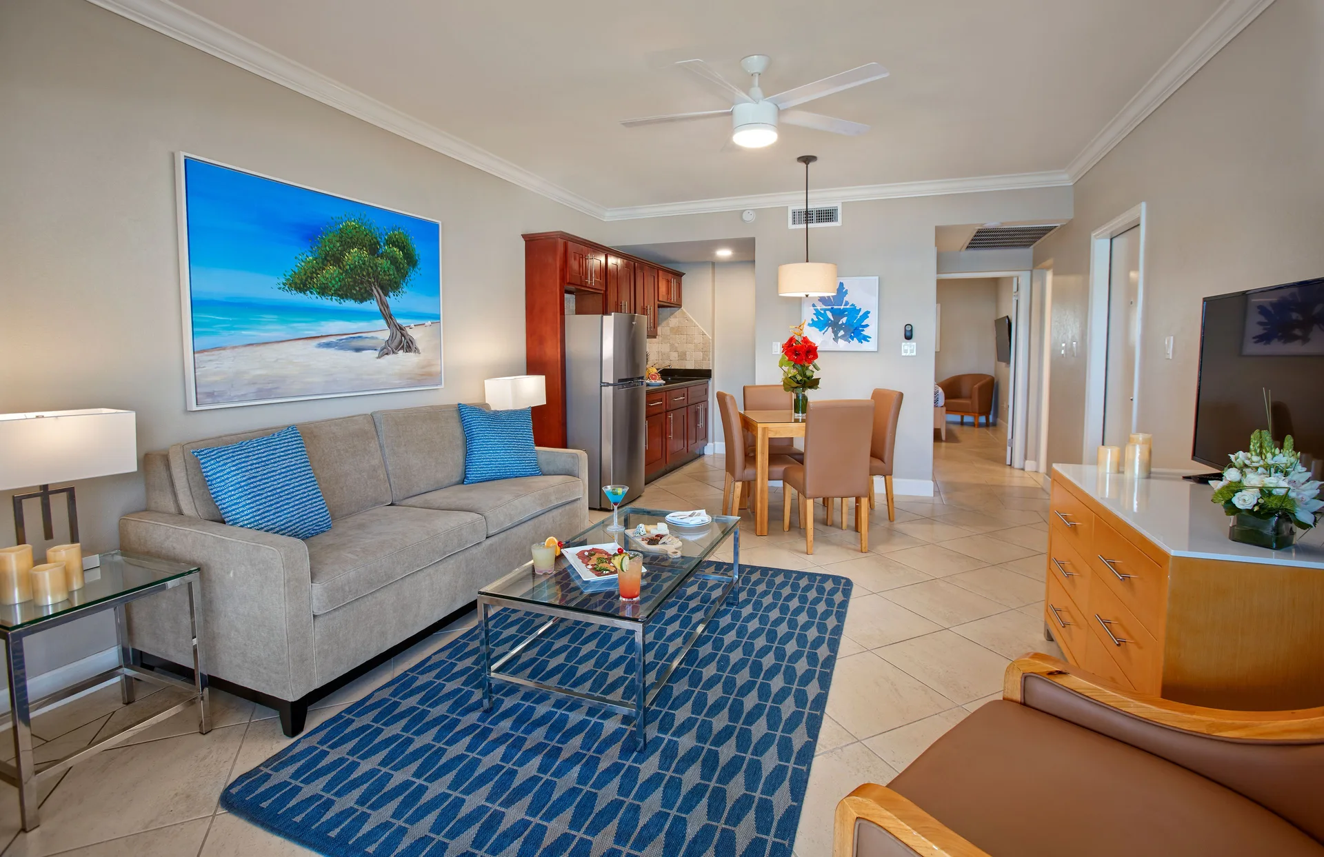 One-bedroom suite living area with sofa, dining table, and kitchen at Divi Little Bay Beach Resort.