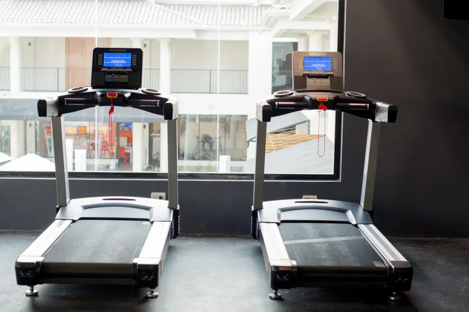 Two treadmills facing windows in the fitness room at Emotions by Hodelpa Puerto Plata.