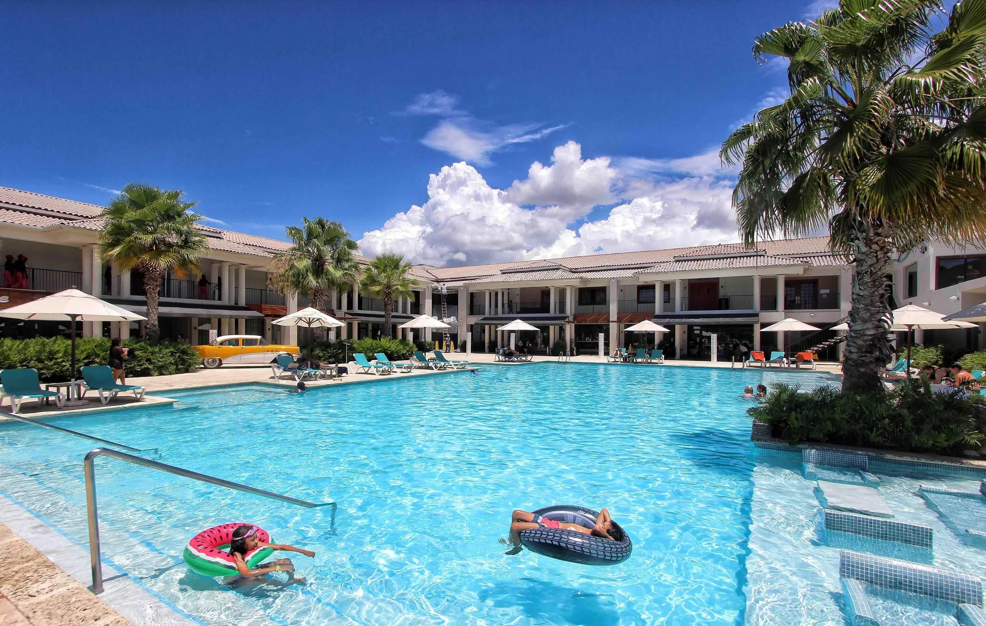 Main pool with loungers and palm trees at Emotions by Hodelpa Puerto Plata.