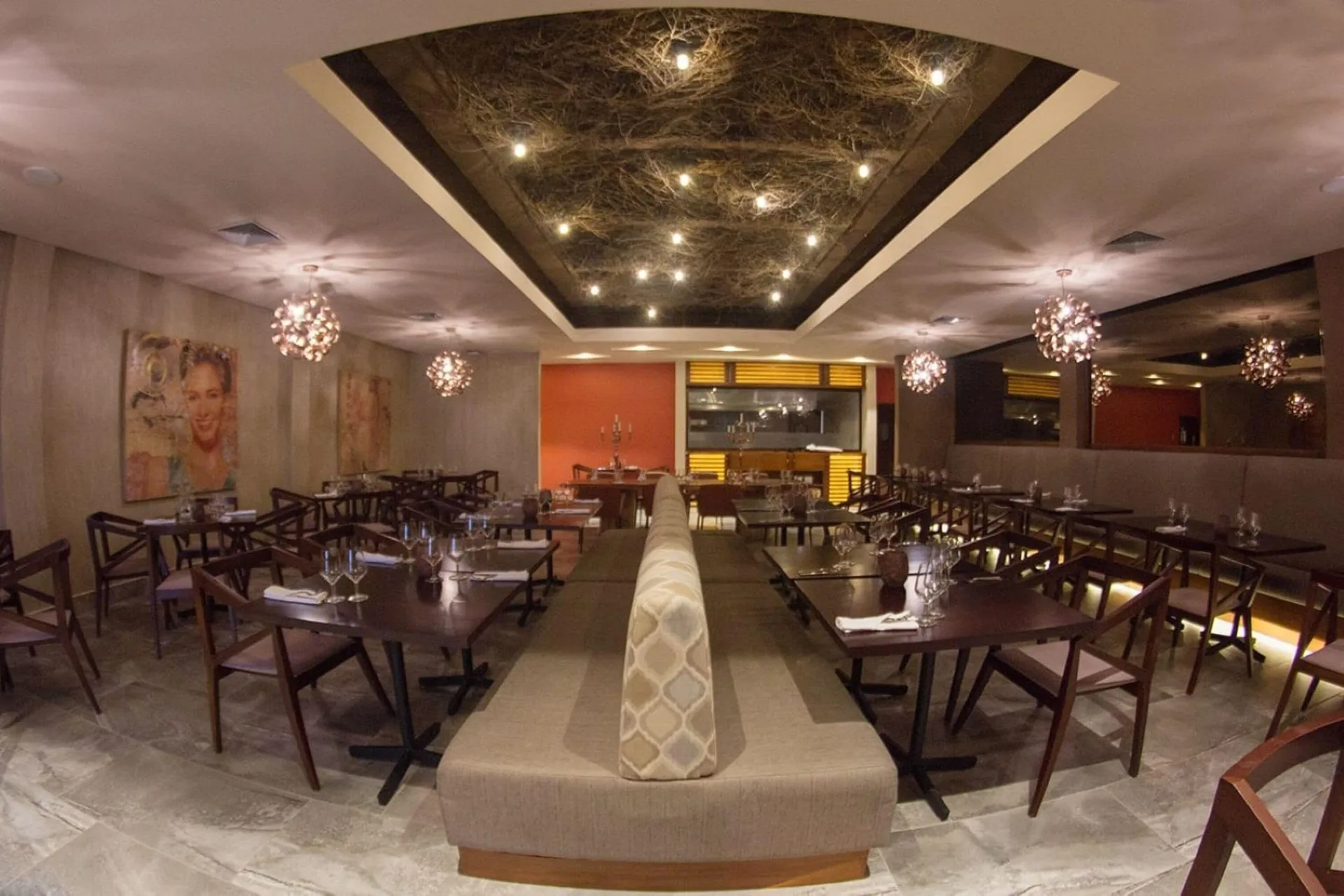 Dim restaurant dining room with set tables at Emotions by Hodelpa Puerto Plata.