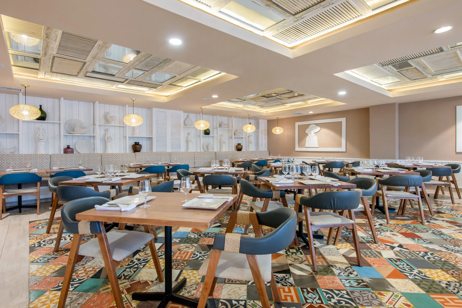 Dining room with set tables and patterned tile floor at Emotions by Hodelpa Puerto Plata.