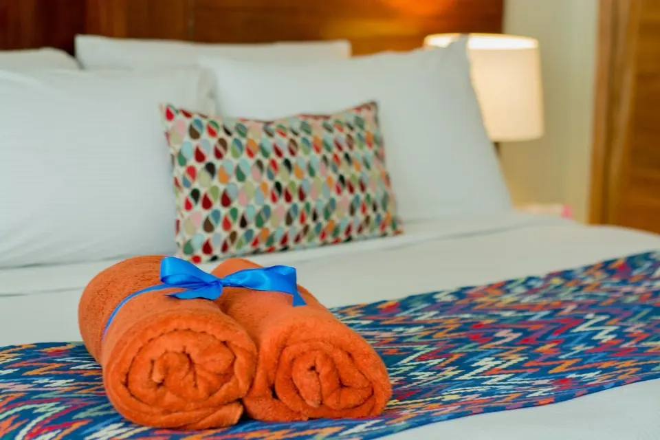 Orange towels on the Adults Only Jr. Suite bed at Emotions by Hodelpa Puerto Plata.