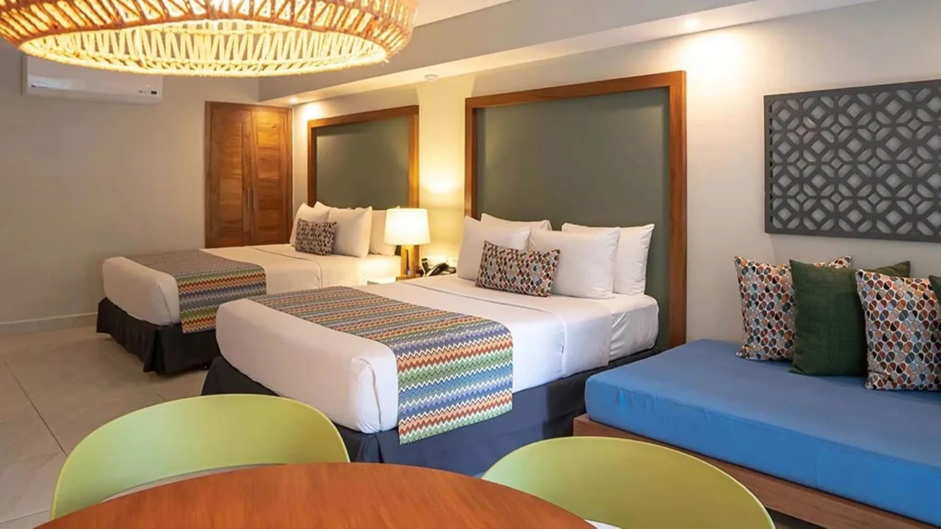 Family Deluxe room with two beds and blue sofa at Emotions by Hodelpa Puerto Plata.