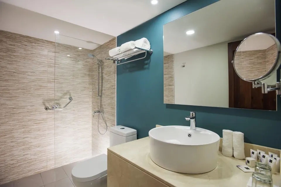 Superior Standard bathroom at Emotions by Hodelpa Puerto Plata with vessel sink, mirror, towels, and shower.