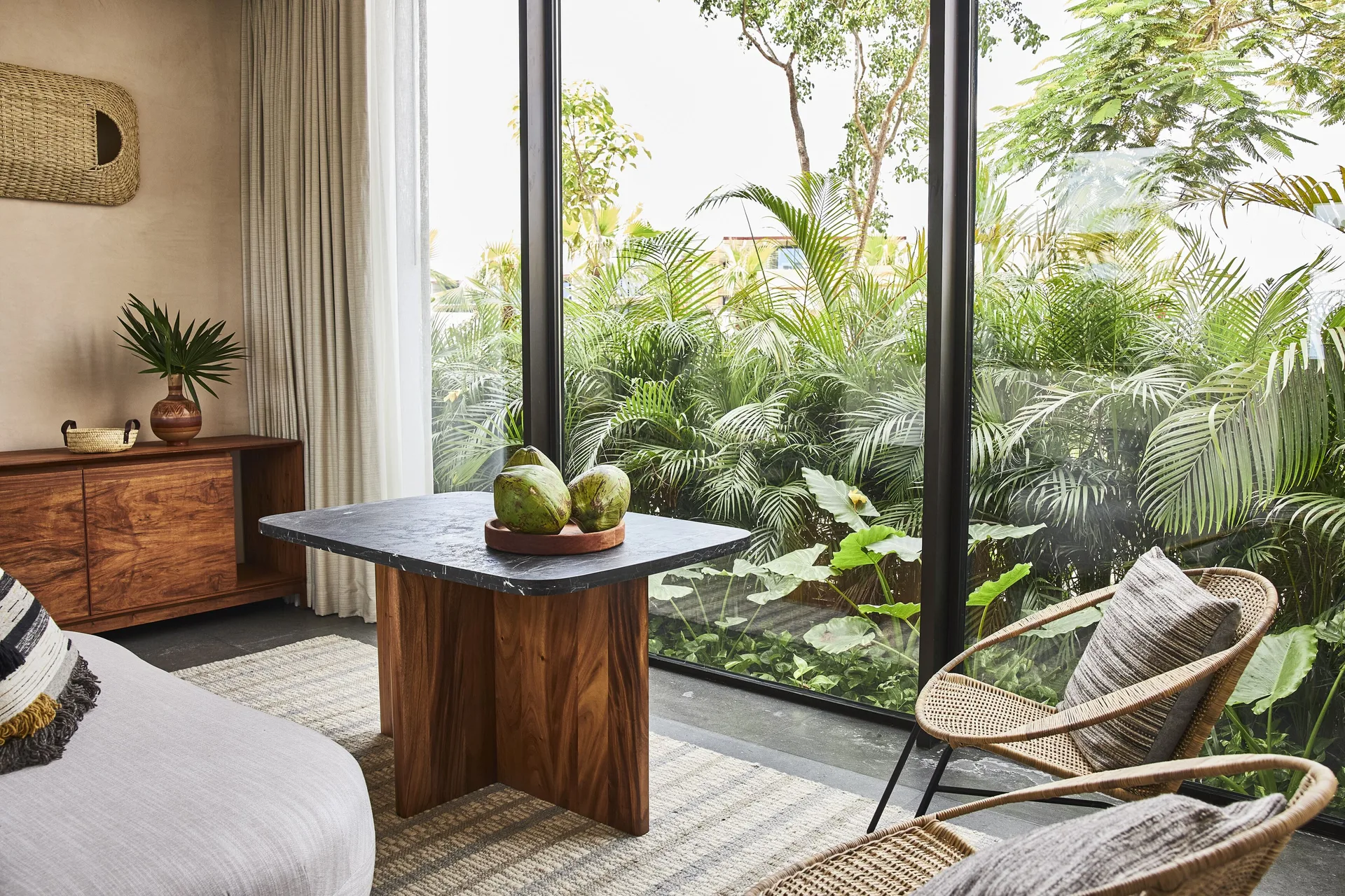 Living area in a one-bedroom suite at Etéreo, Auberge Collection with garden-view windows.