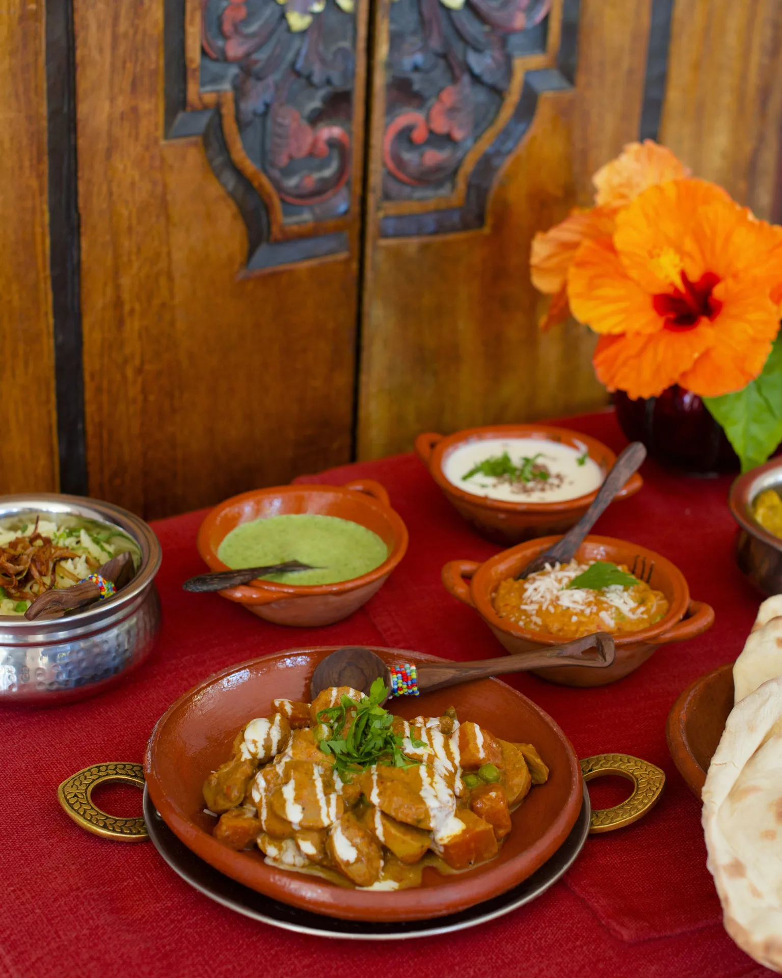 Indian-style dishes with sauces, bread, and flowers at Excellence Playa Mujeres.