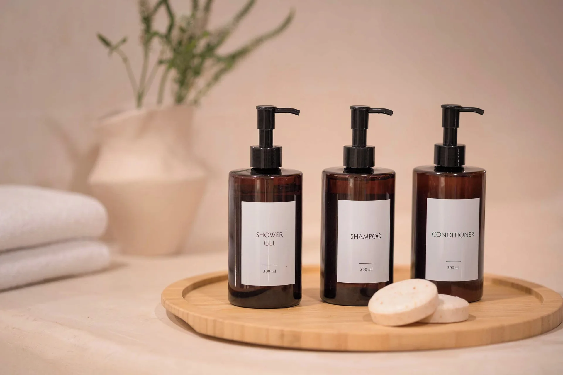 Bathroom amenities with pump bottles, soap, towels, and vase at Excellence Playa Mujeres.