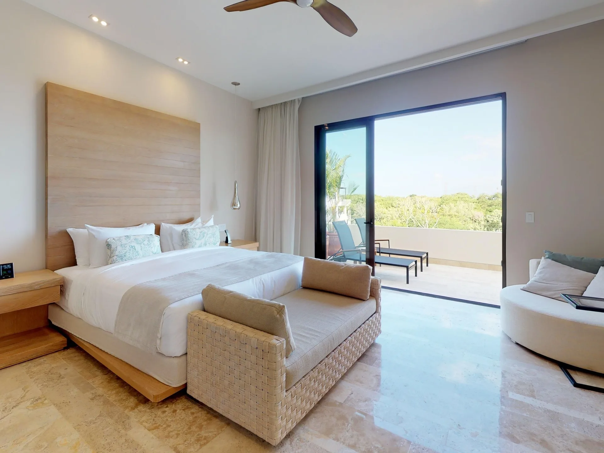 Guest room with king bed, chaise, and balcony seating at Fairmont Heritage Place Mayakoba.