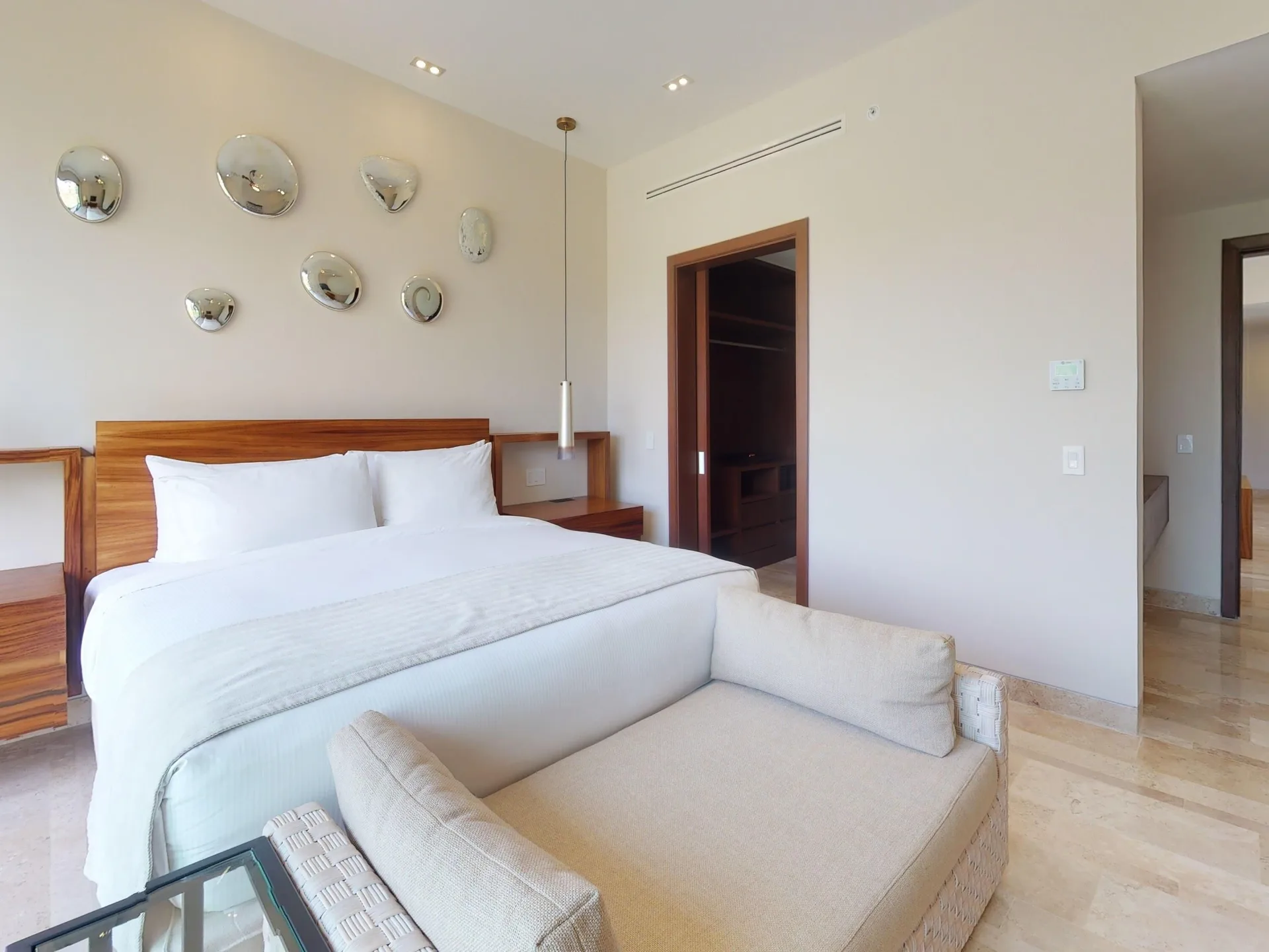 Guest room with king bed, chaise, and wall mirrors at Fairmont Heritage Place Mayakoba.