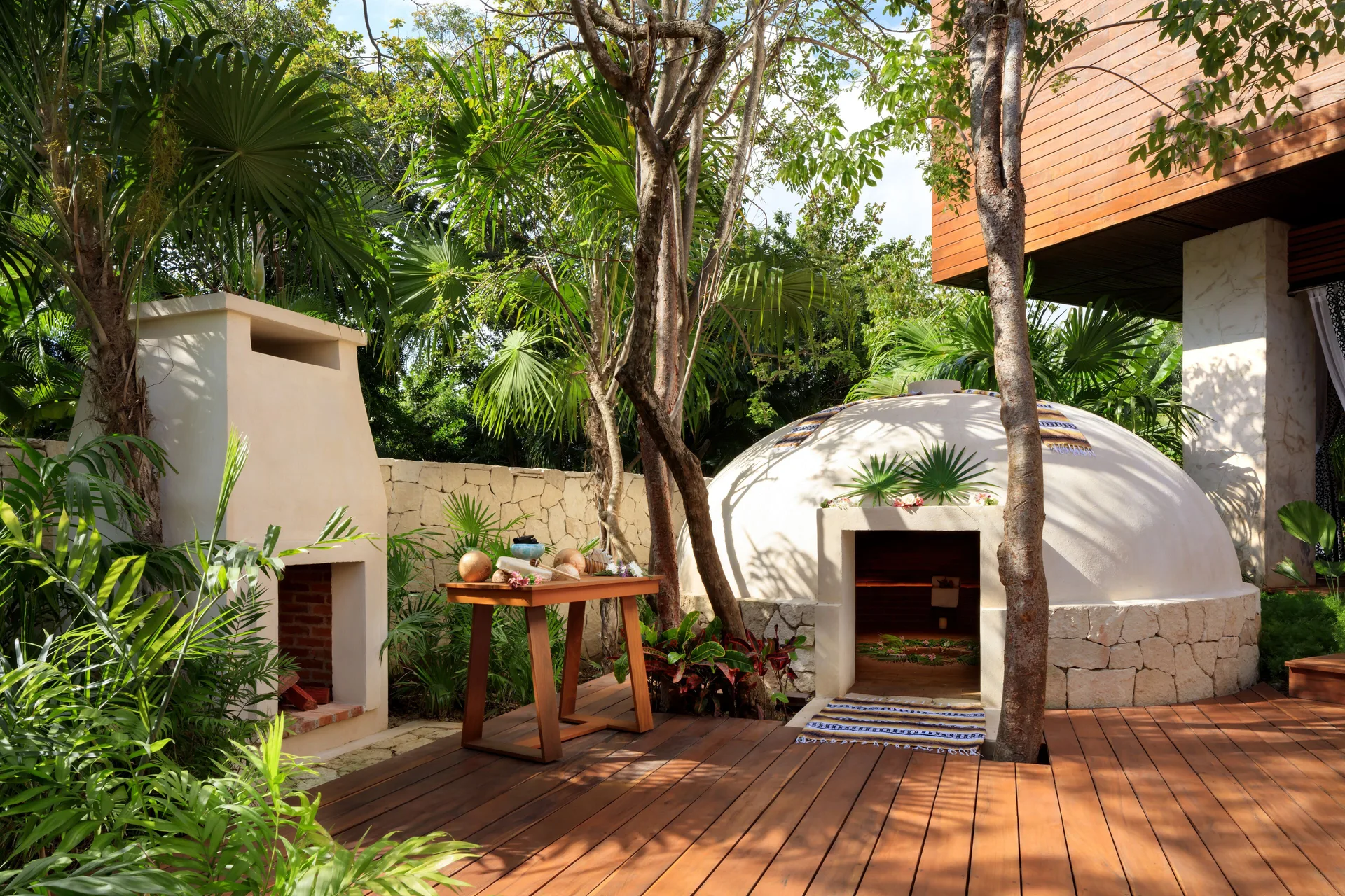 Outdoor spa area with temazcal-style dome and fireplace at Fairmont Heritage Place Mayakoba.