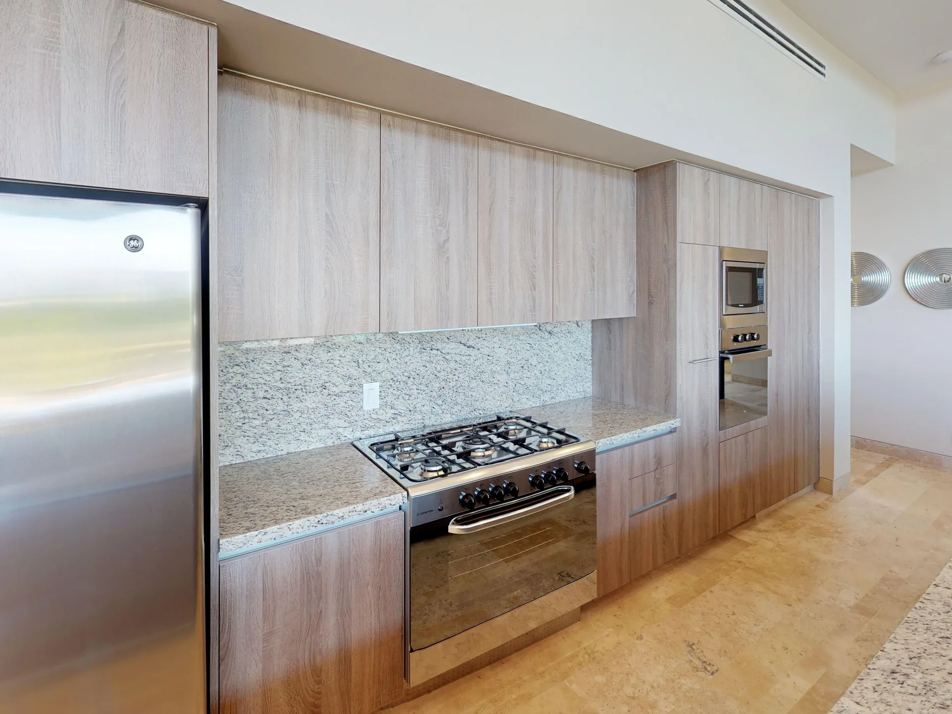 Kitchen with wood cabinetry and stainless appliances at Fairmont Heritage Place Mayakoba.