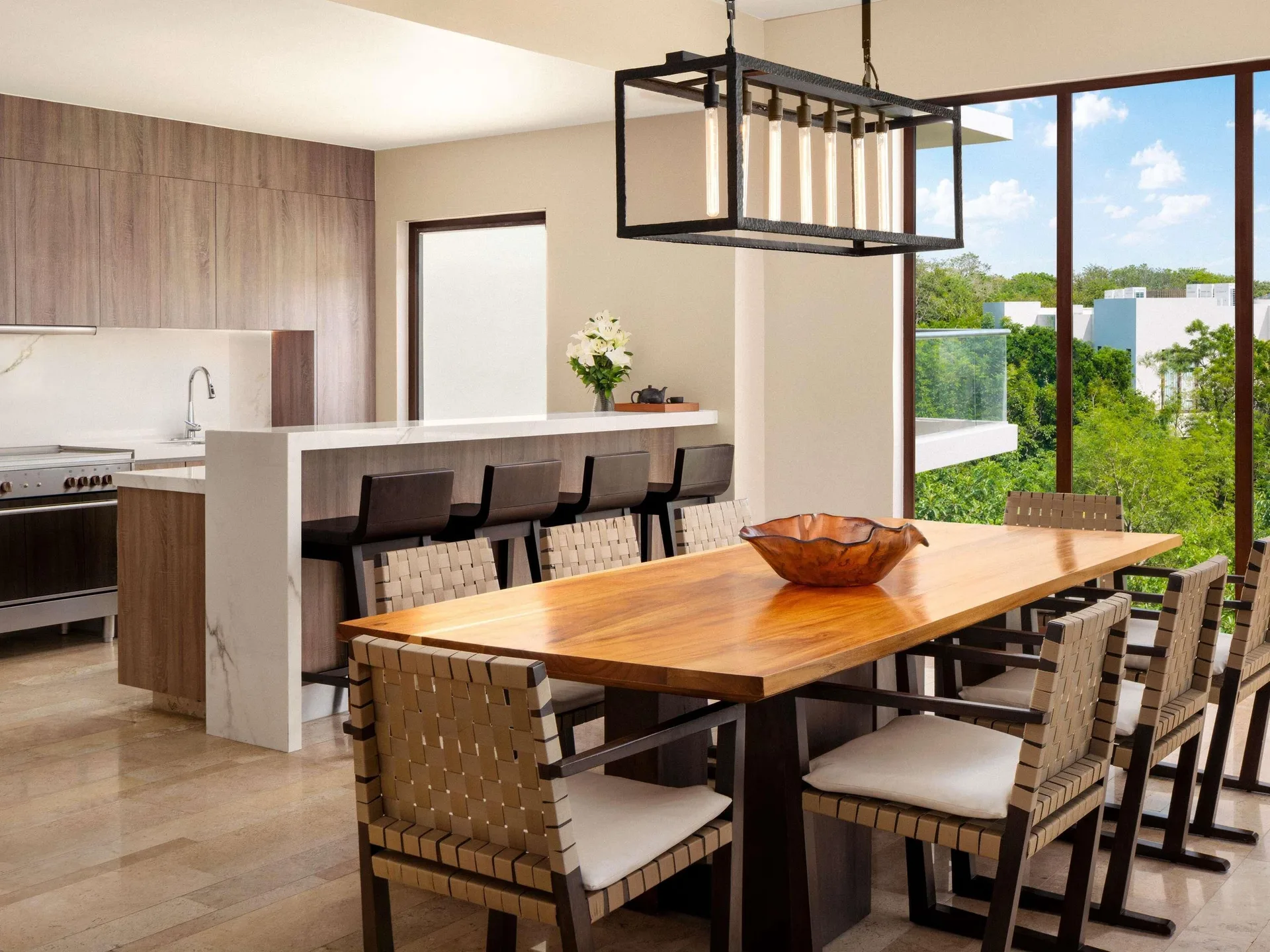 Dining area and kitchen with treetop windows at Fairmont Heritage Place Mayakoba.