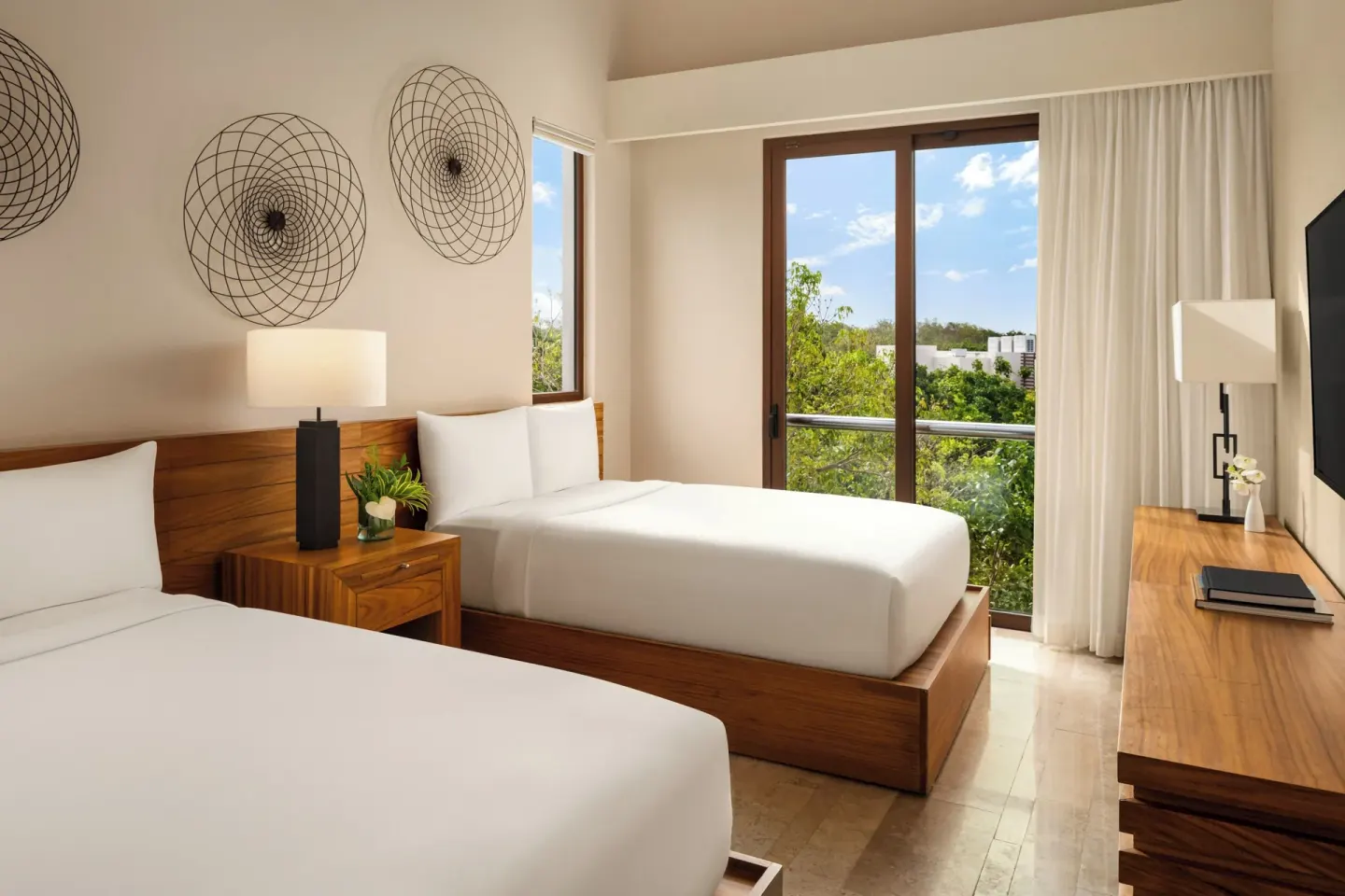 Bedroom with two double beds and balcony doors at Fairmont Heritage Place Mayakoba.