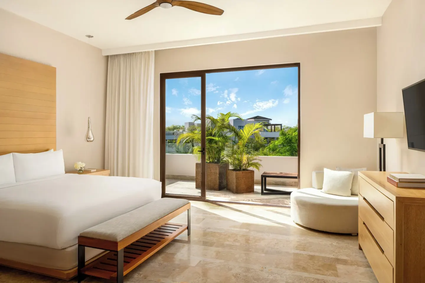 Bedroom with a king bed and balcony plants in a penthouse villa at Fairmont Heritage Place Mayakoba.