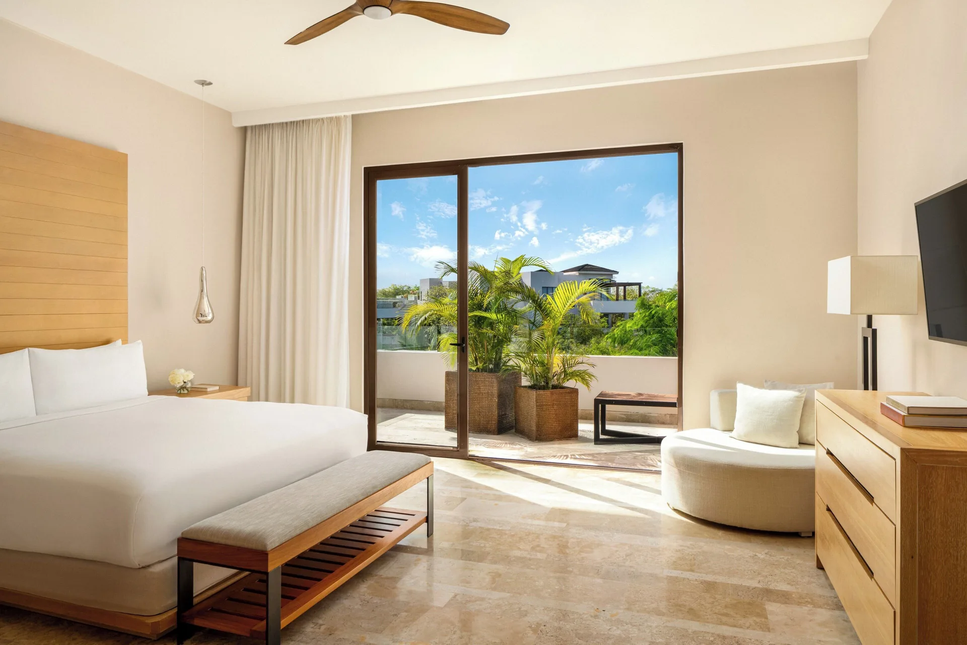 Bedroom with a king bed and balcony plants in a penthouse villa at Fairmont Heritage Place Mayakoba.
