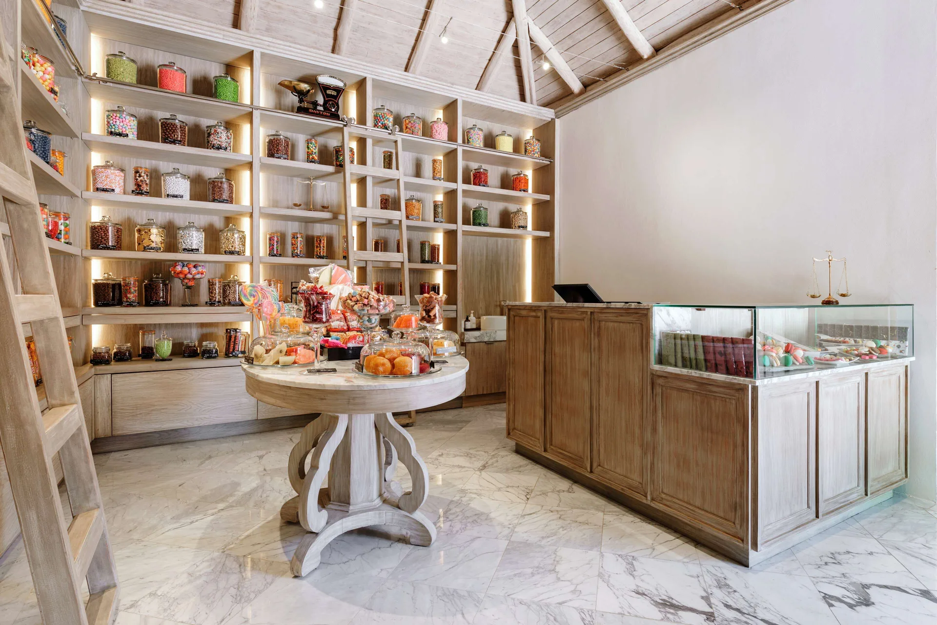 Candy shop with glass jars, display cases, and wood shelving at Fairmont Mayakoba.