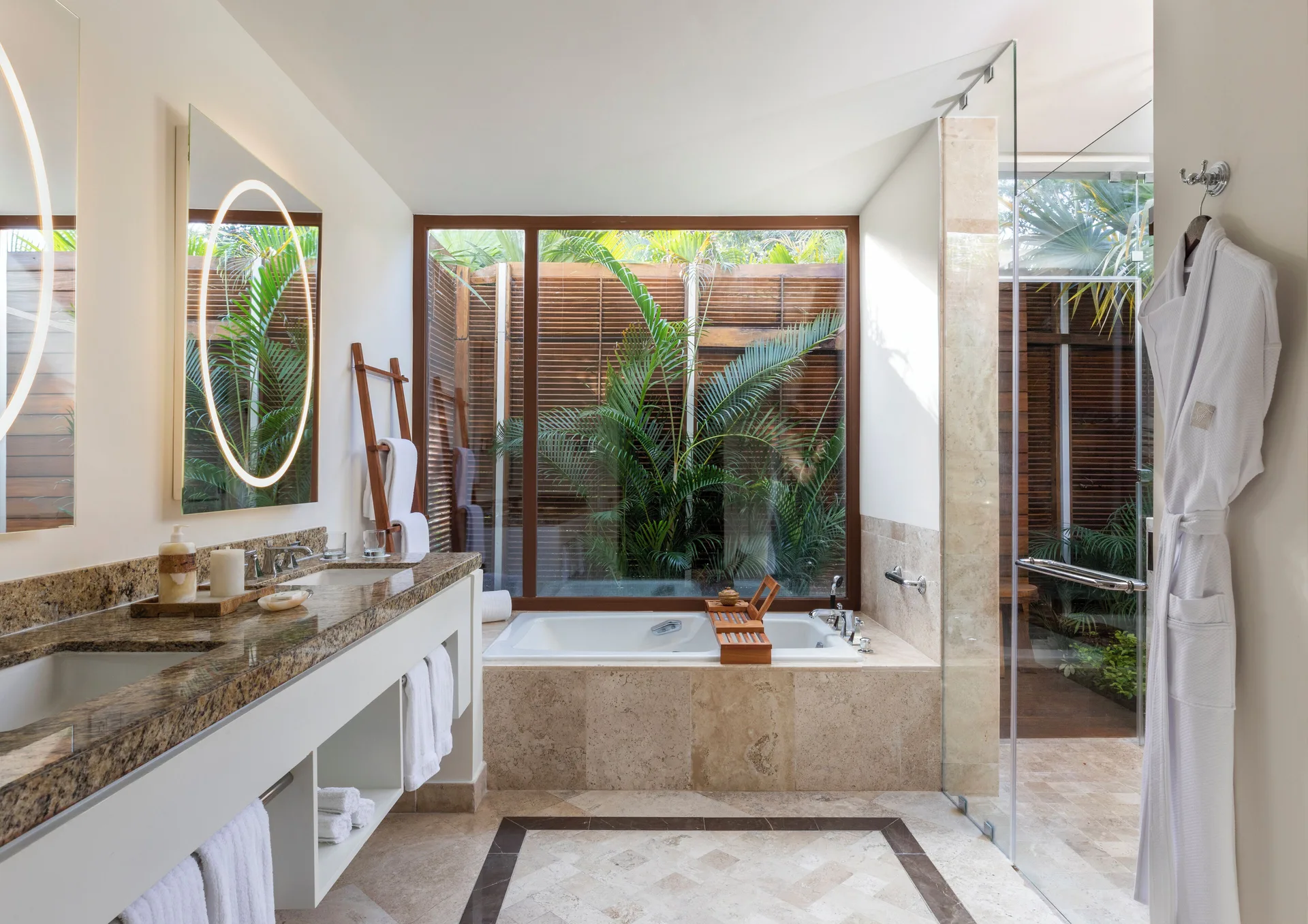 Bright bathroom with soaking tub, vanity and robe at Fairmont Mayakoba.