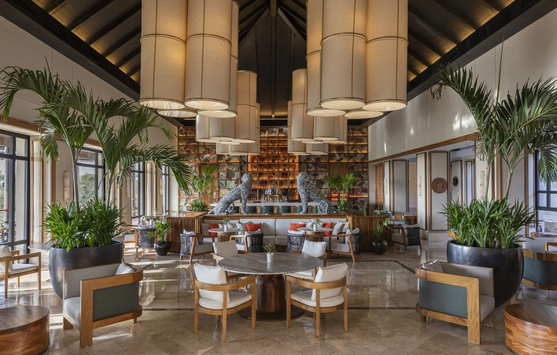 Lobby lounge with large pendant lights and tropical plants at Fairmont Mayakoba.