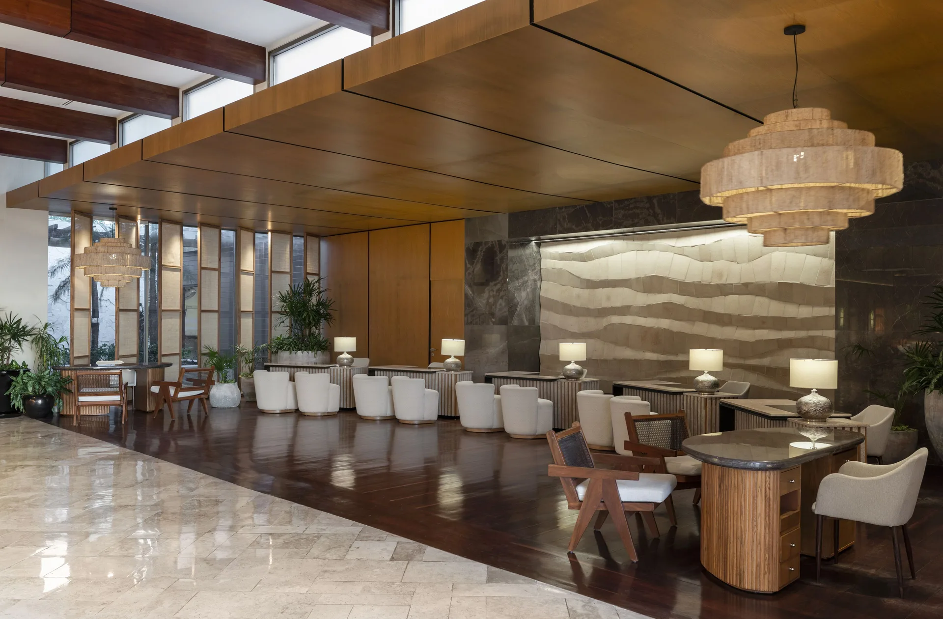 Lobby lounge with marble floors, wood ceilings, tables, and pendant lights at Fairmont Mayakoba.