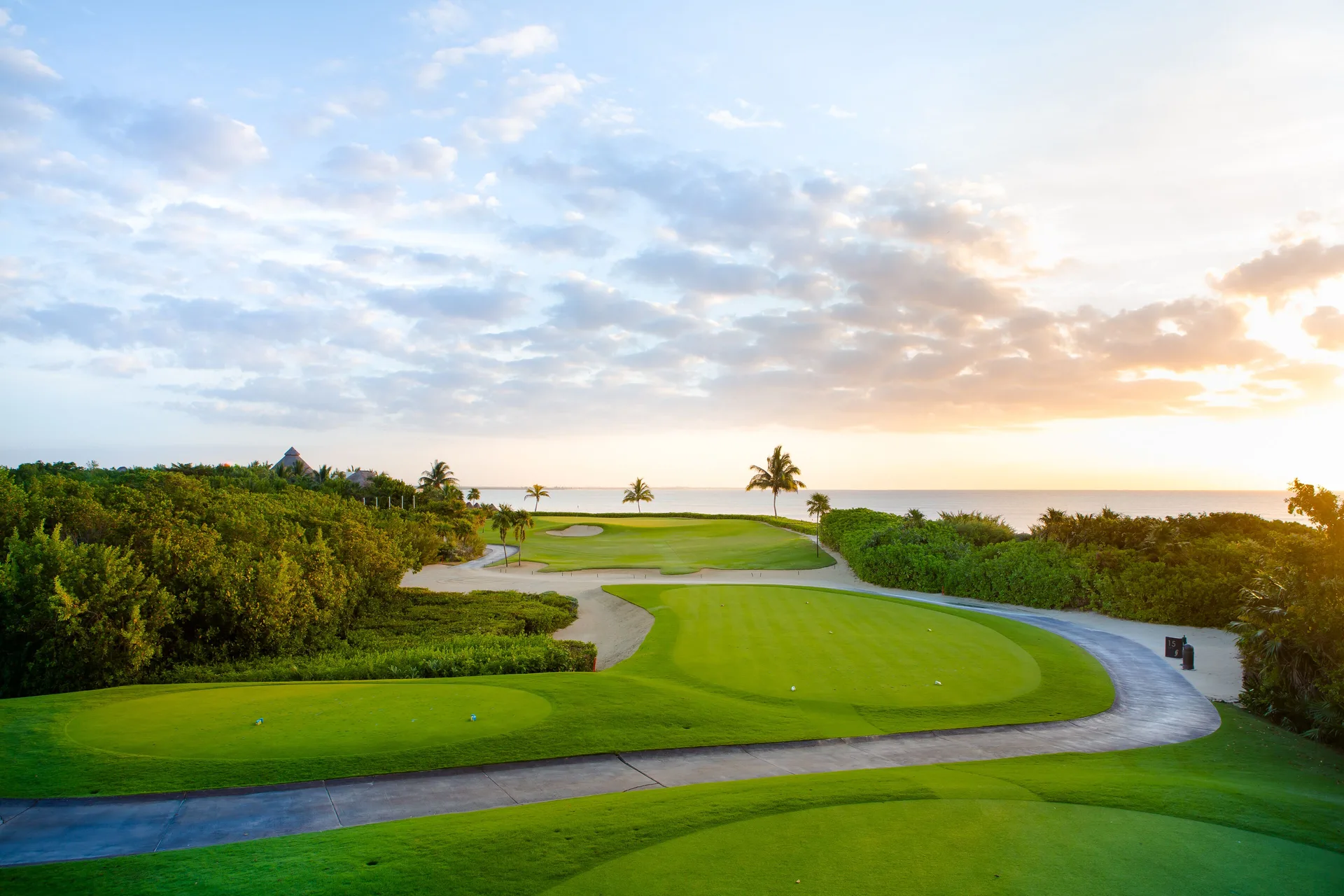 Oceanfront golf course greens and cart path at sunrise at Fairmont Mayakoba.