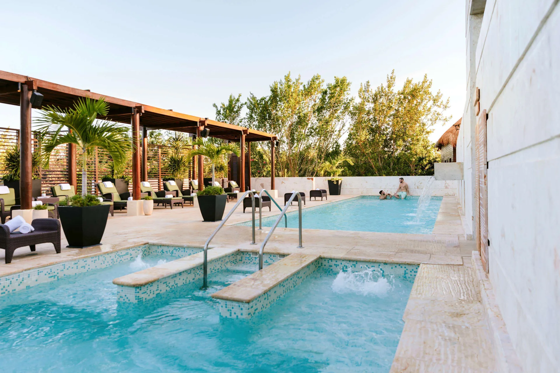 Spa pool with lounge chairs and pergola seating at Fairmont Mayakoba.