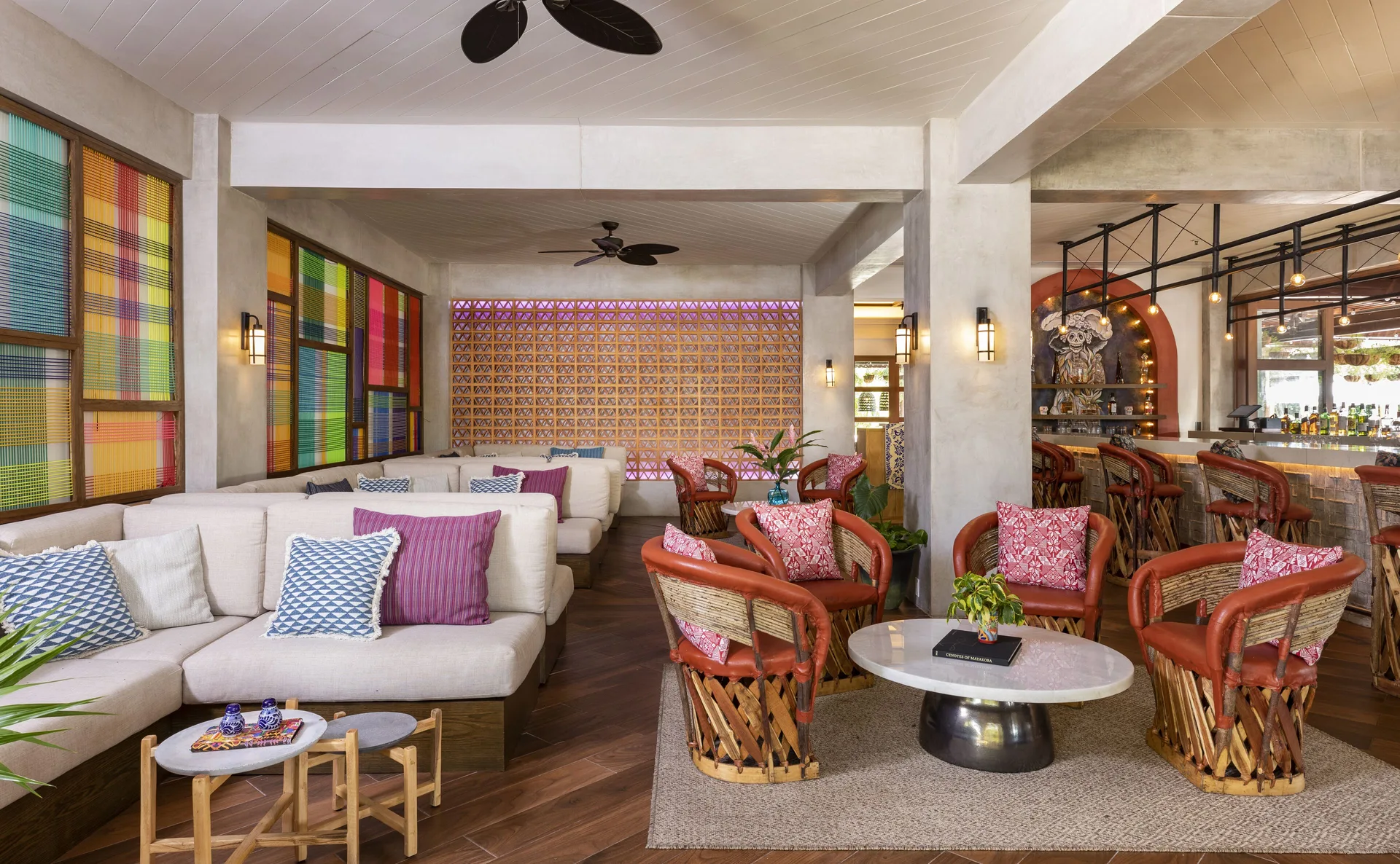 Colorful bar lounge with sofas, woven chairs and bar seating at Fairmont Mayakoba.