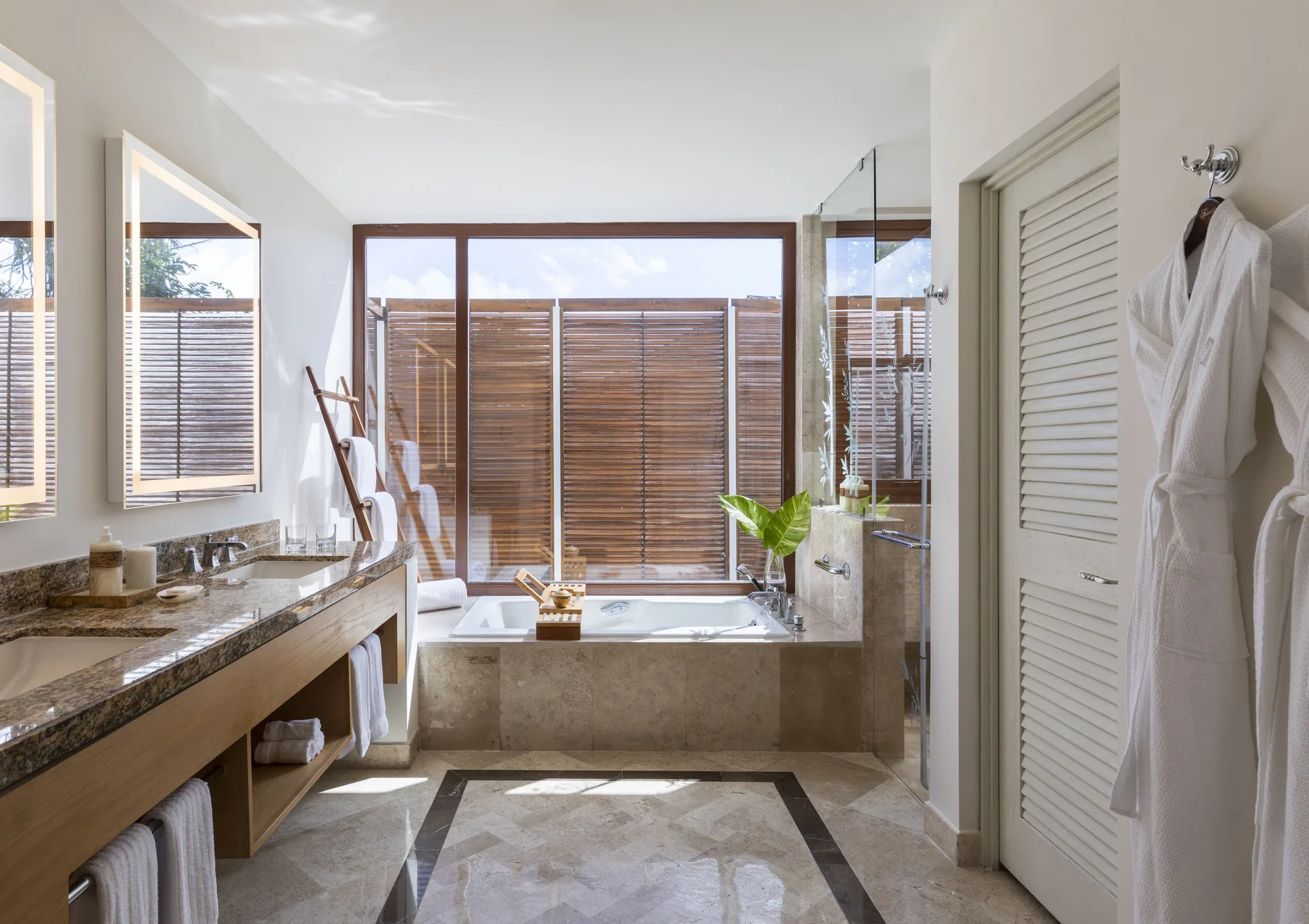 Bathroom in a Casita Deluxe Room at Fairmont Mayakoba with soaking tub, double vanity, and robes.