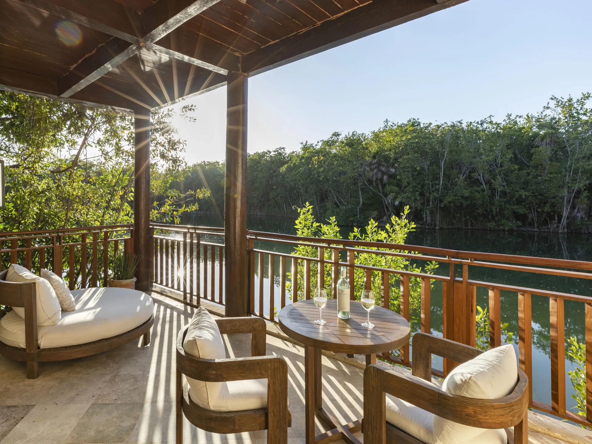 Furnished casita terrace beside a canal and trees at Fairmont Mayakoba.