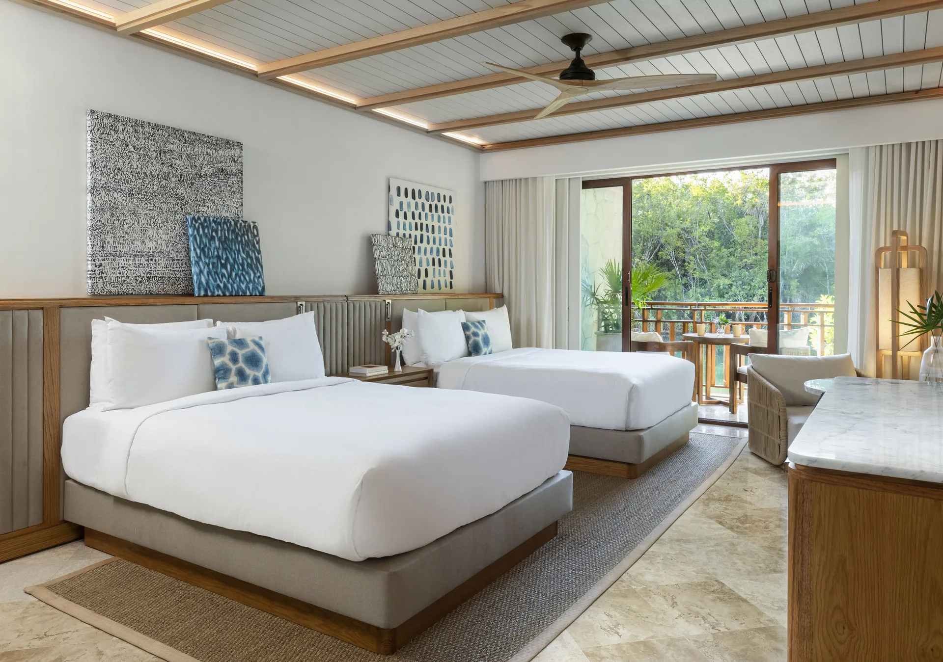 Casita room with two beds and a balcony overlooking greenery at Fairmont Mayakoba.