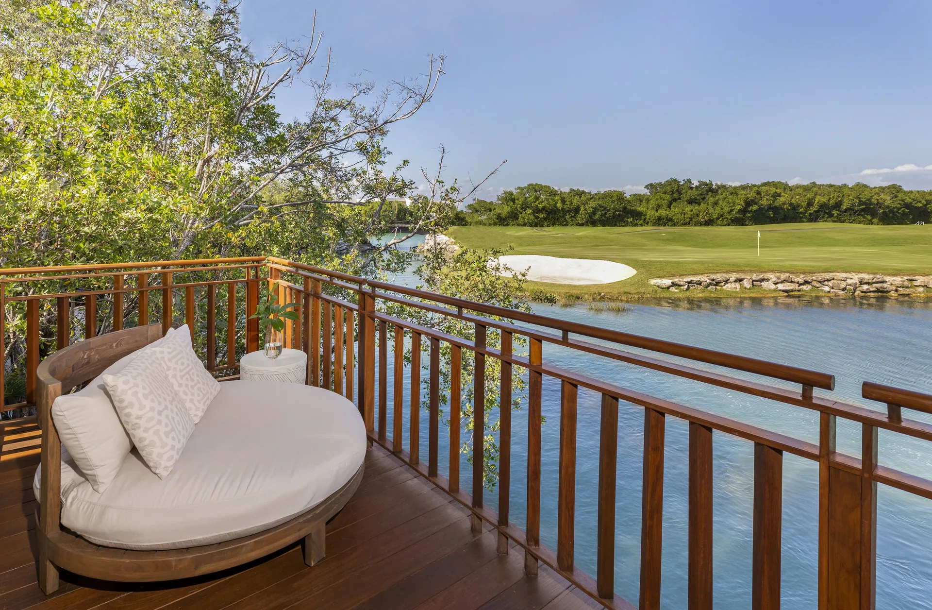 Casita Signature Room balcony at Fairmont Mayakoba with a round daybed overlooking water and golf greens.