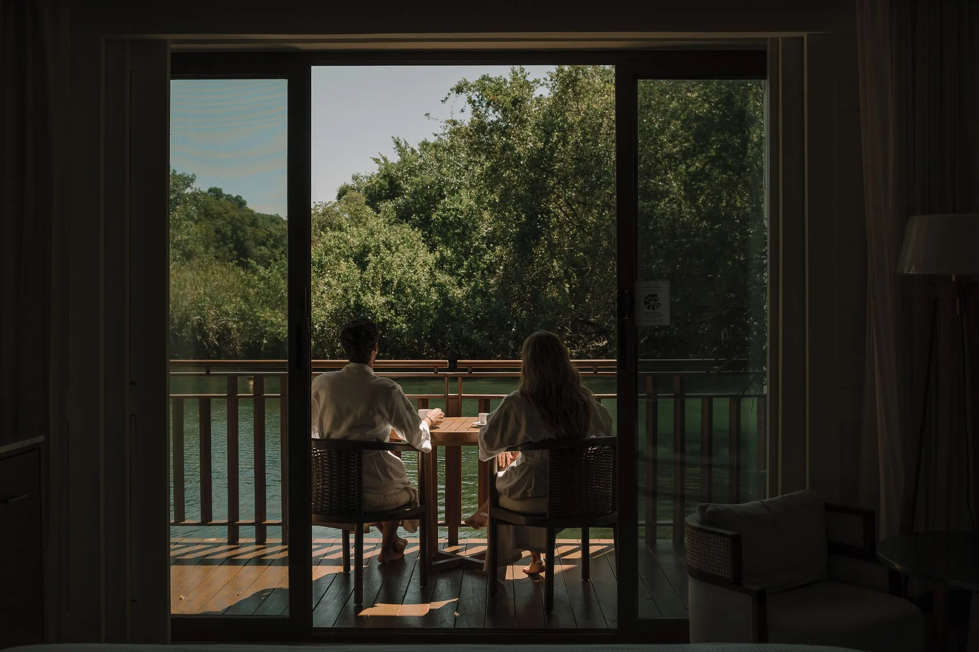 Casita Signature Room balcony at Fairmont Mayakoba with two guests seated by the water.