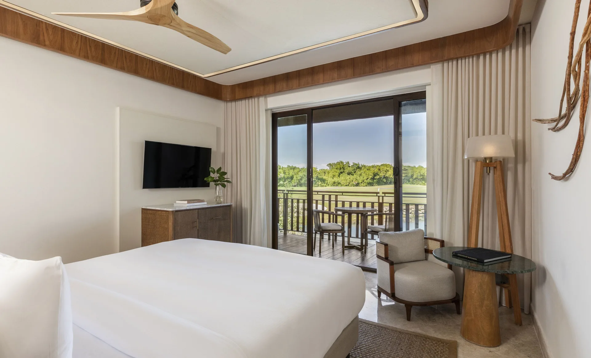 Casita Signature Room at Fairmont Mayakoba with a king bed and balcony overlooking water and greenery.