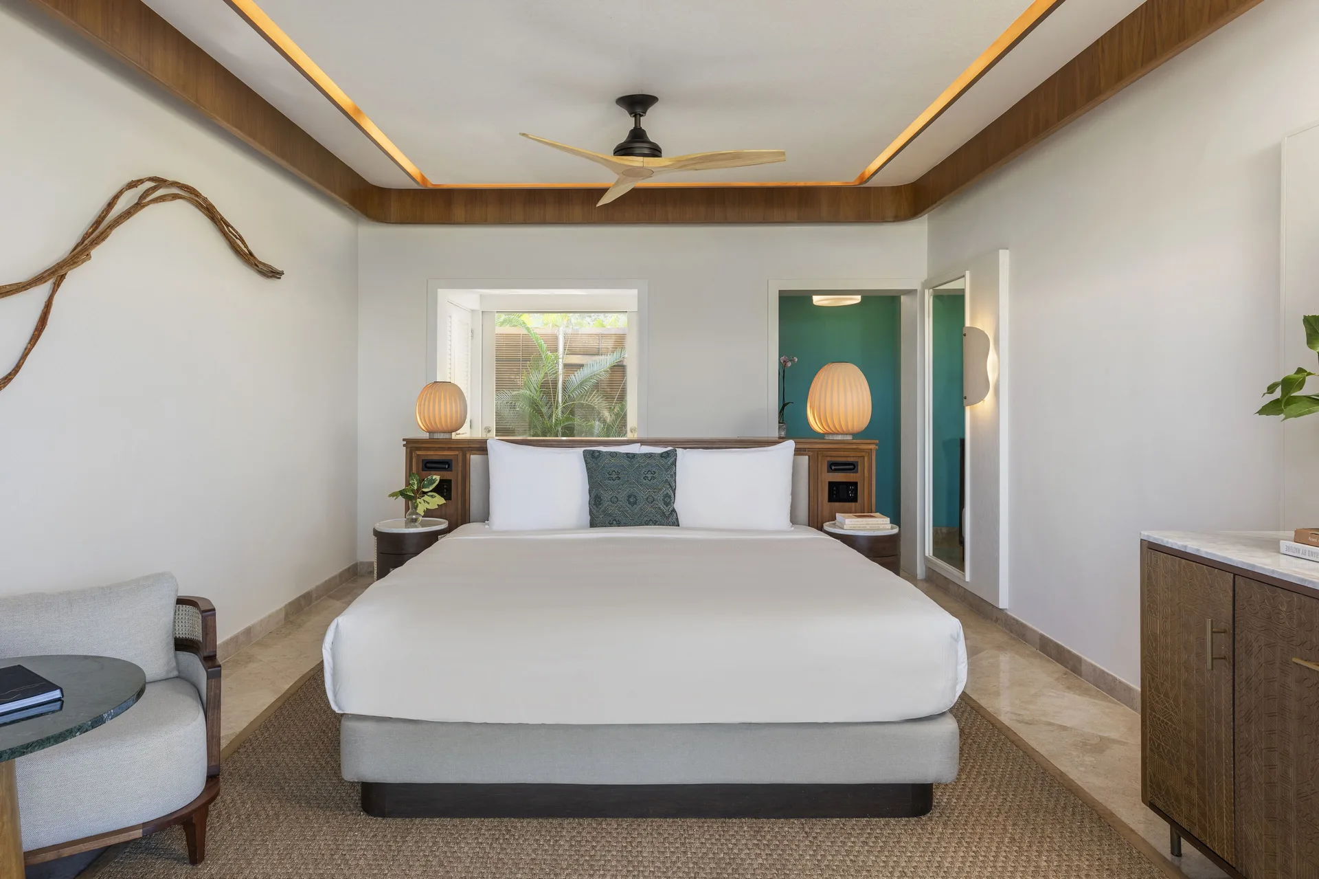 King bed in a Casita Signature Room at Fairmont Mayakoba with lamps and wood-trimmed ceiling.
