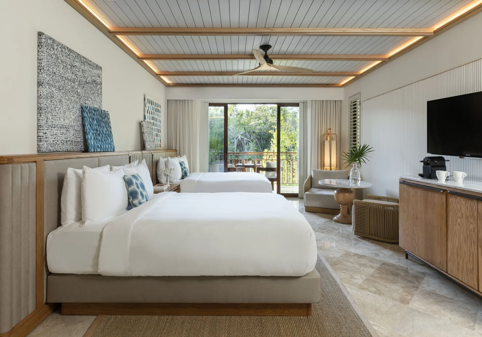 Casita Signature Room at Fairmont Mayakoba with two queen beds, art, TV, and balcony beyond.