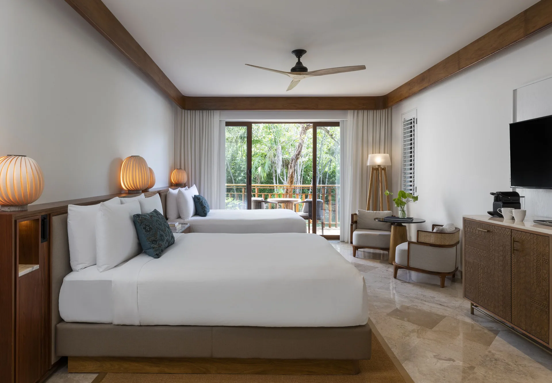 Casita Signature Room at Fairmont Mayakoba with two queen beds, seating, TV, and balcony doors.