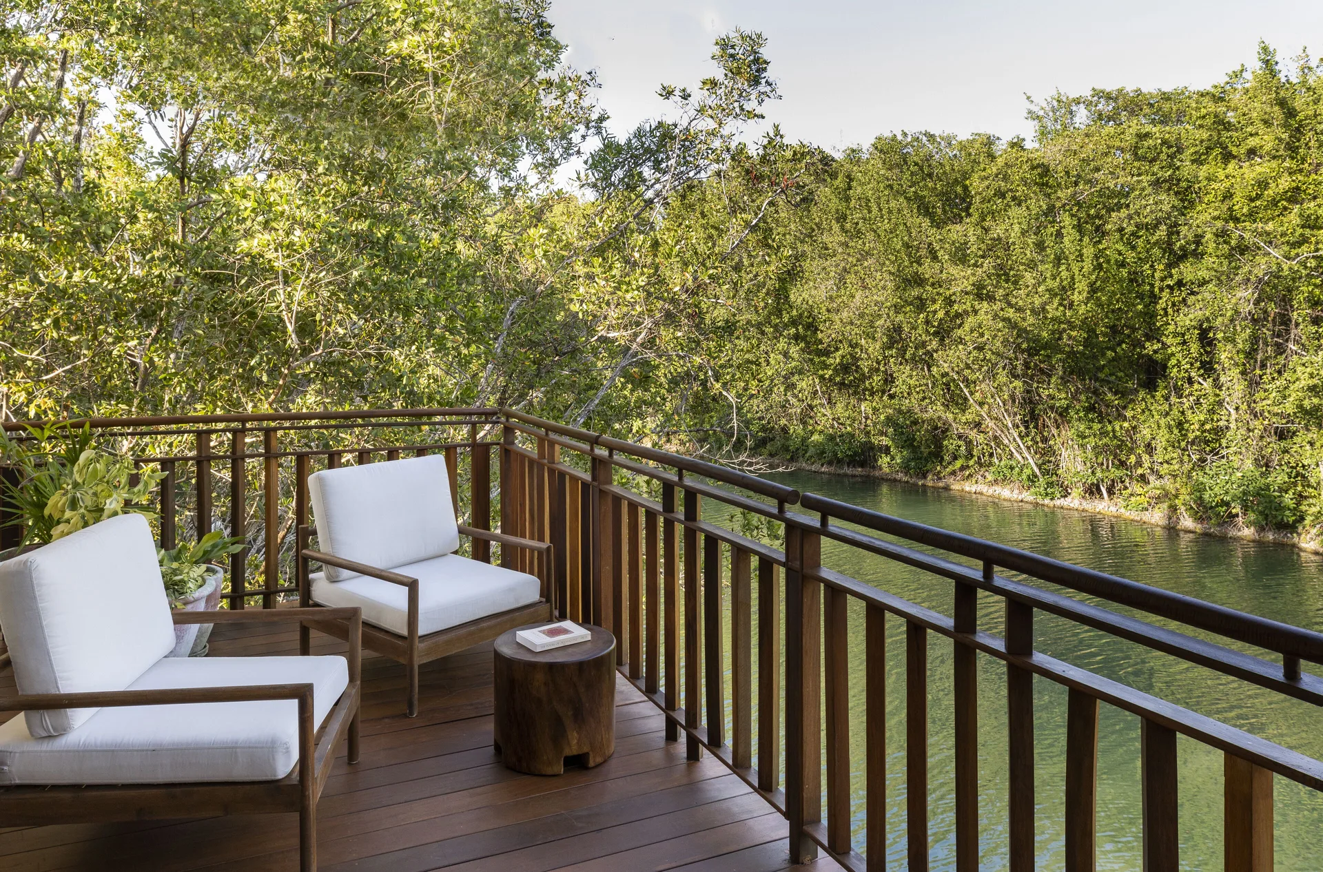 Canal-view balcony with cushioned chairs at Fairmont Mayakoba.