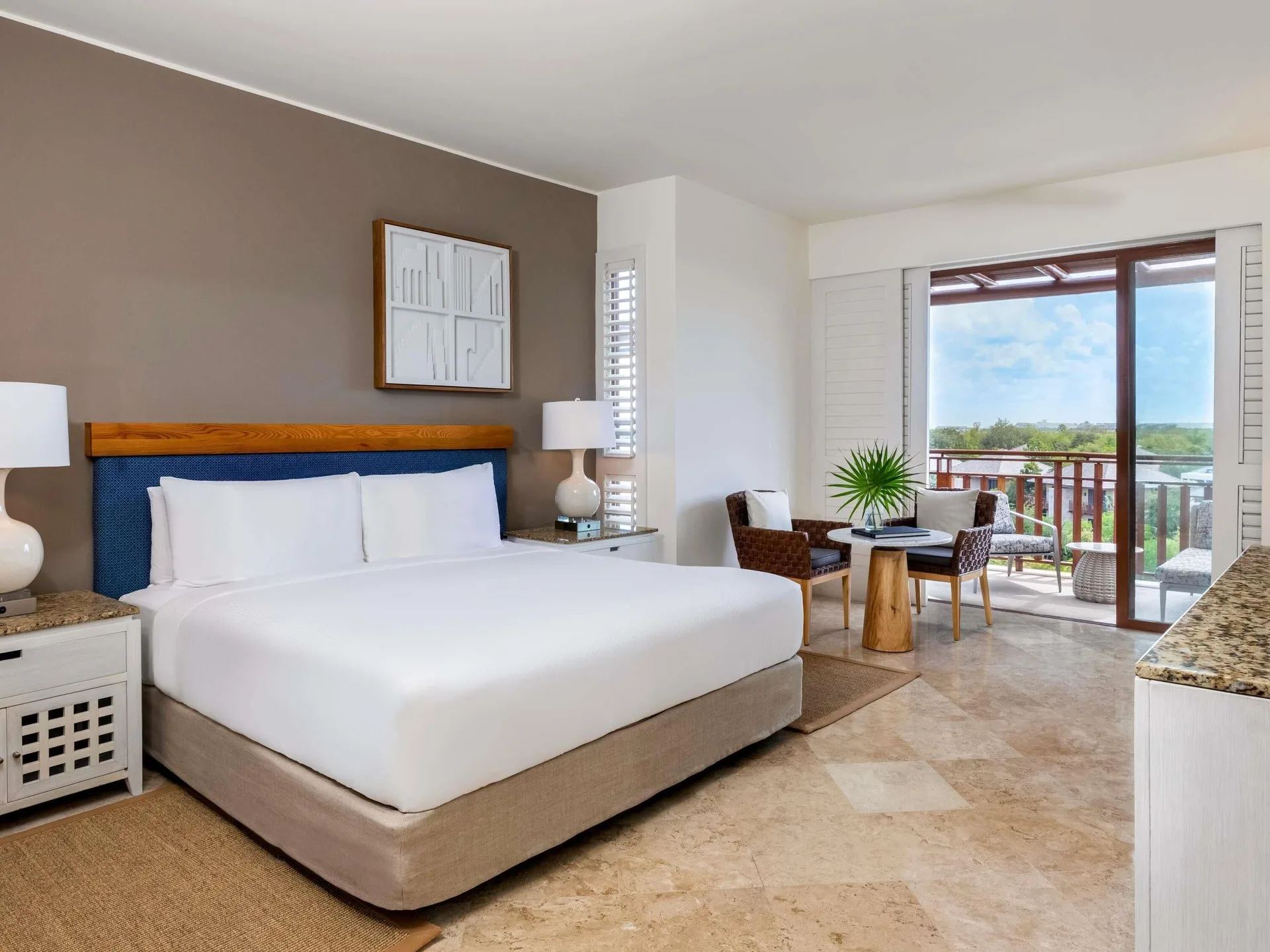 King bed, sitting area, and balcony in a Family Room at Fairmont Mayakoba.