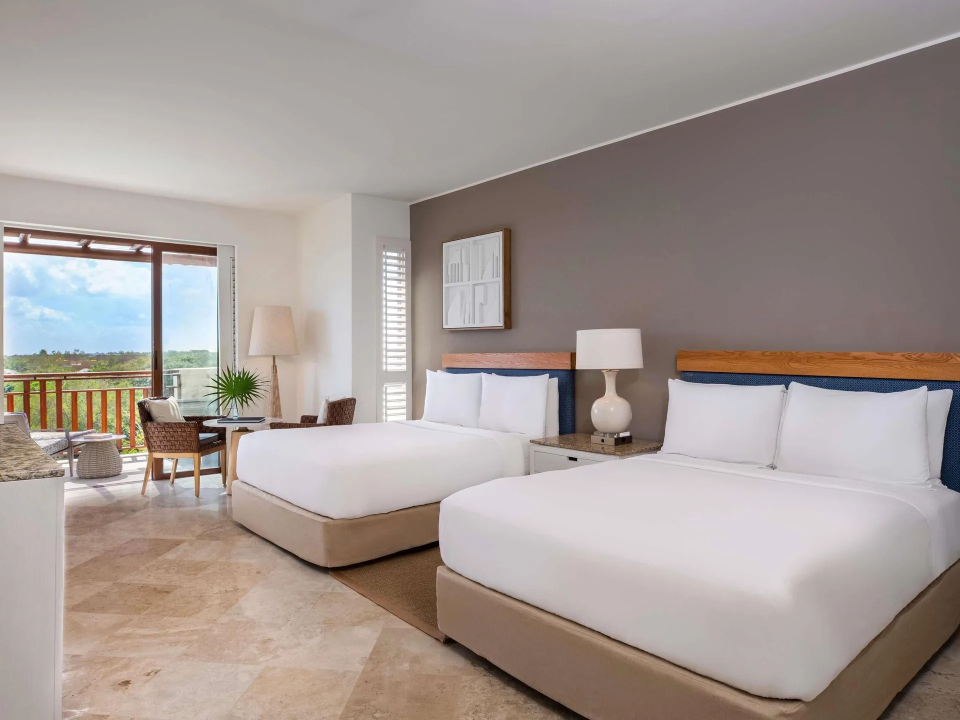 Two beds, sitting area, and balcony in connecting Family Rooms at Fairmont Mayakoba.
