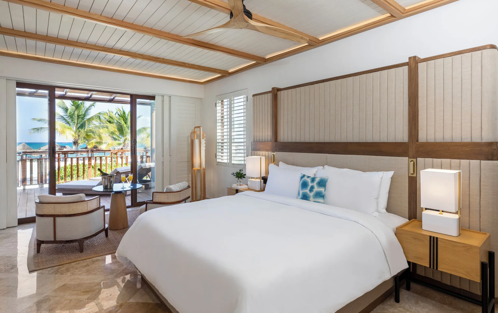 Beachfront premium suite bedroom with king bed and balcony view at Fairmont Mayakoba.