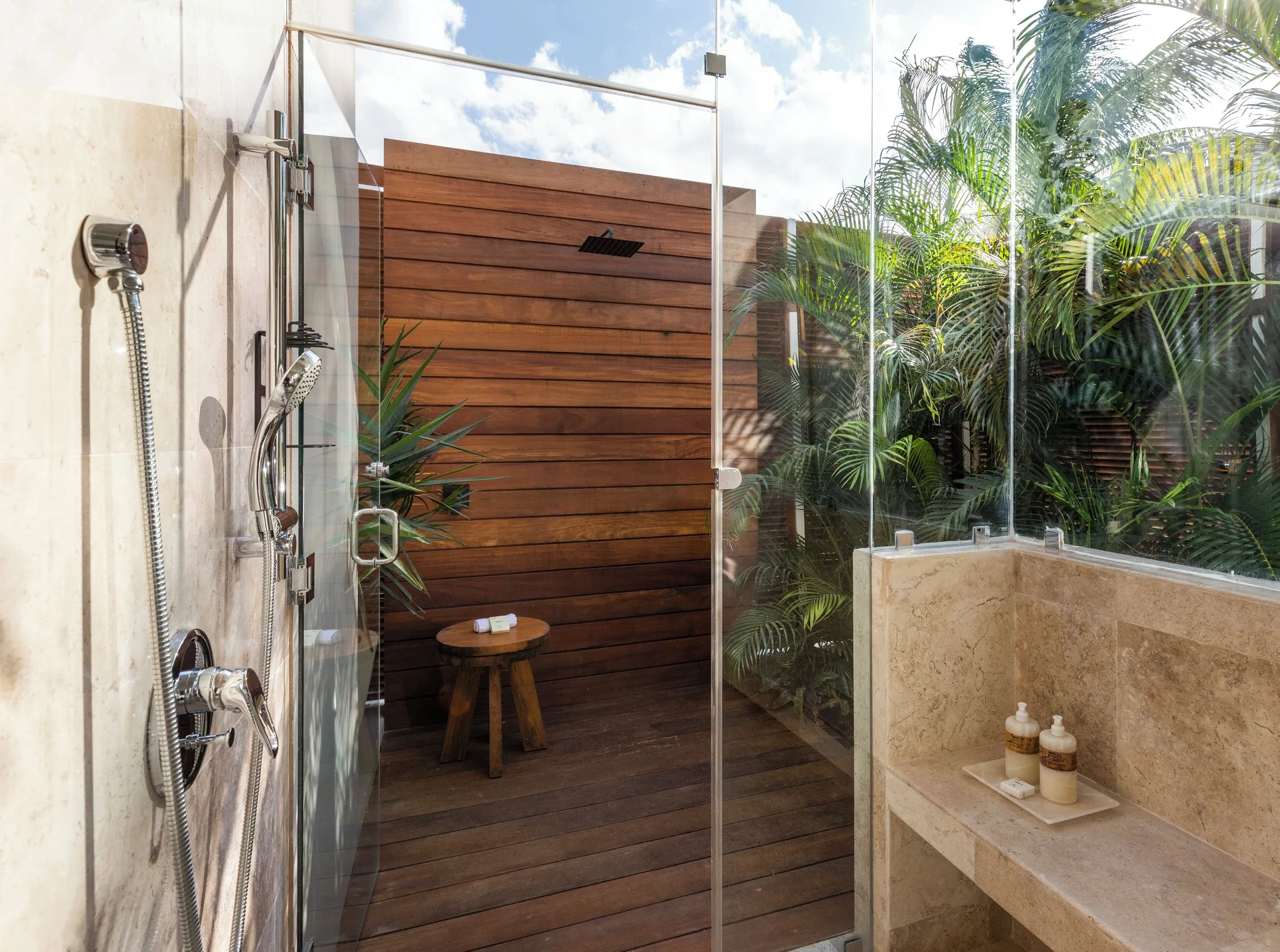Premium Suite outdoor shower with glass enclosure and tropical plants at Fairmont Mayakoba.